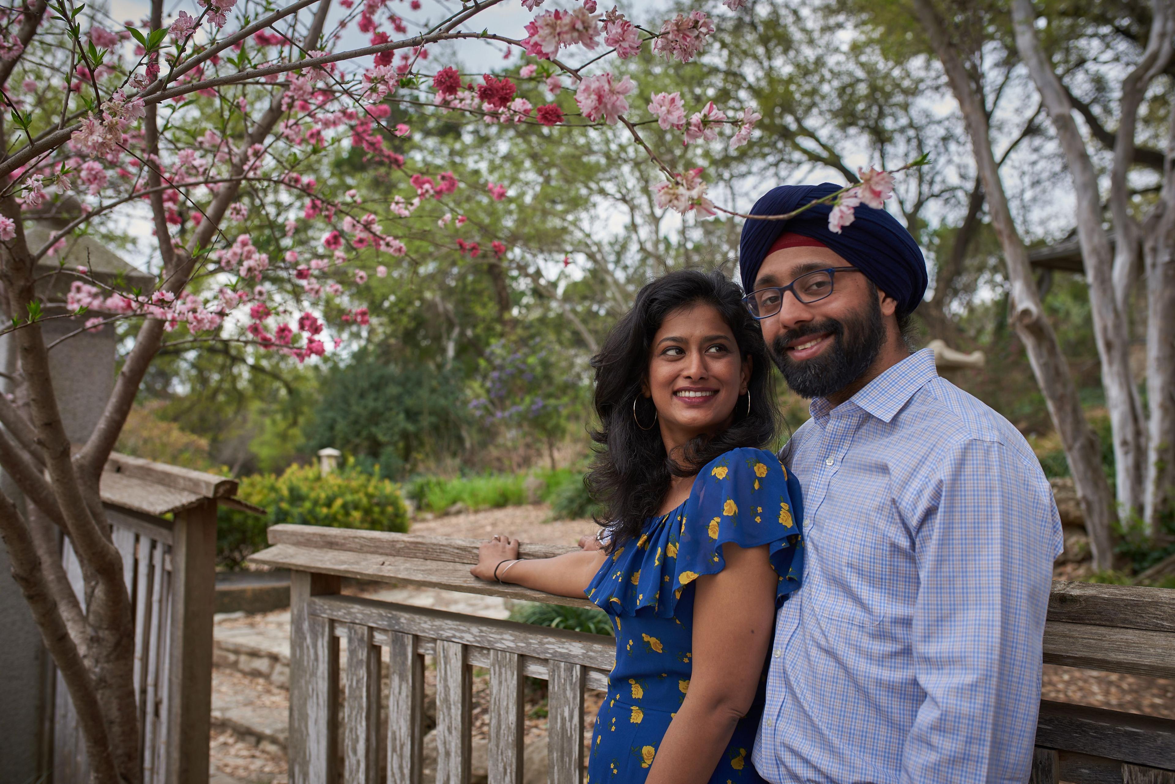 Couple standing together beneath a pink flowering tree in bloom at Zilker Botanical Garden — Zilker Botanical Gardens photography, Austin A couple standing together beneath a pink flowering tree in bloom at Zilker Botanical Garden