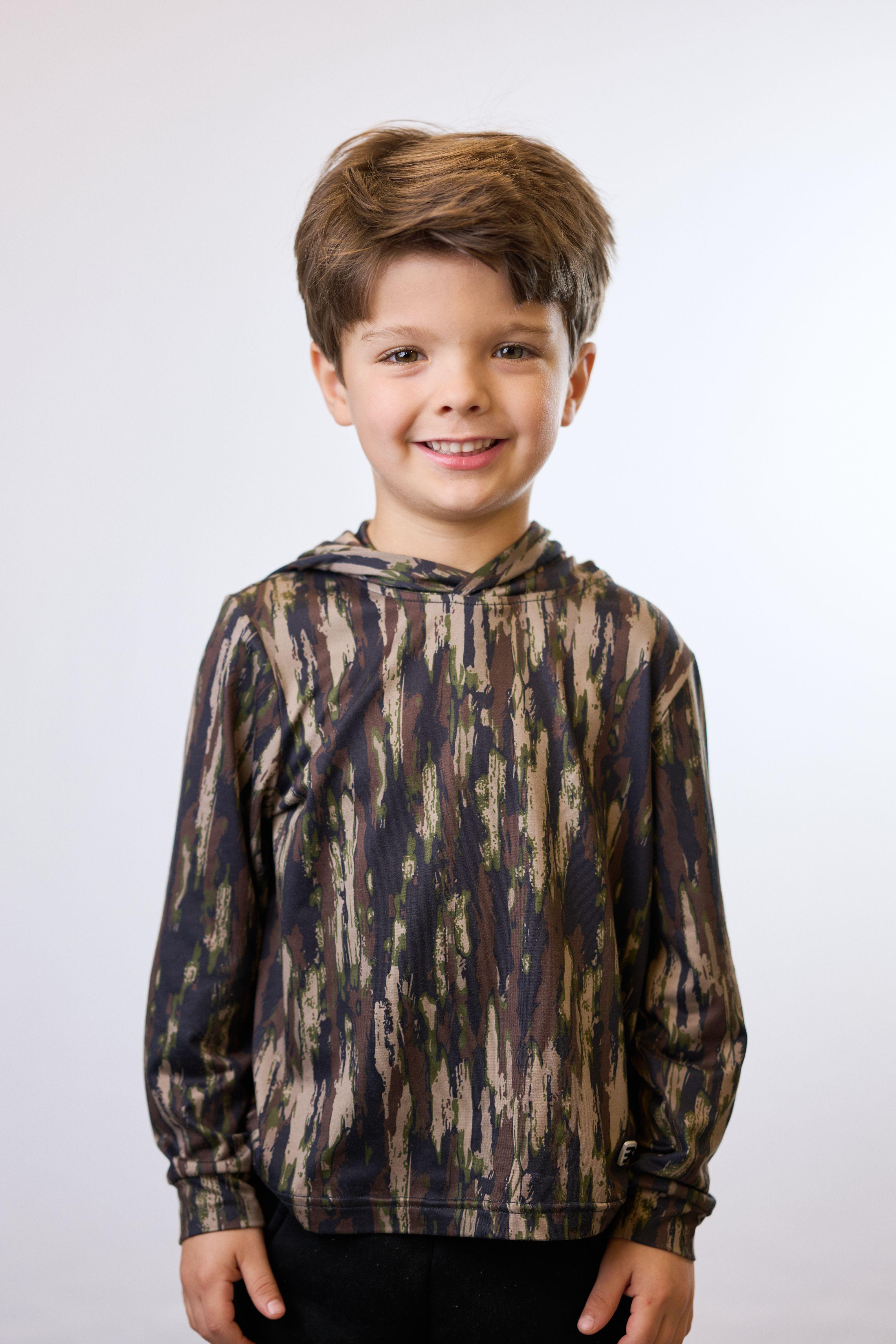 Young boy in a patterned hooded top smiling on white seamless — Commercial photo studio, Austin Young boy in a patterned hooded top smiling on white seamless