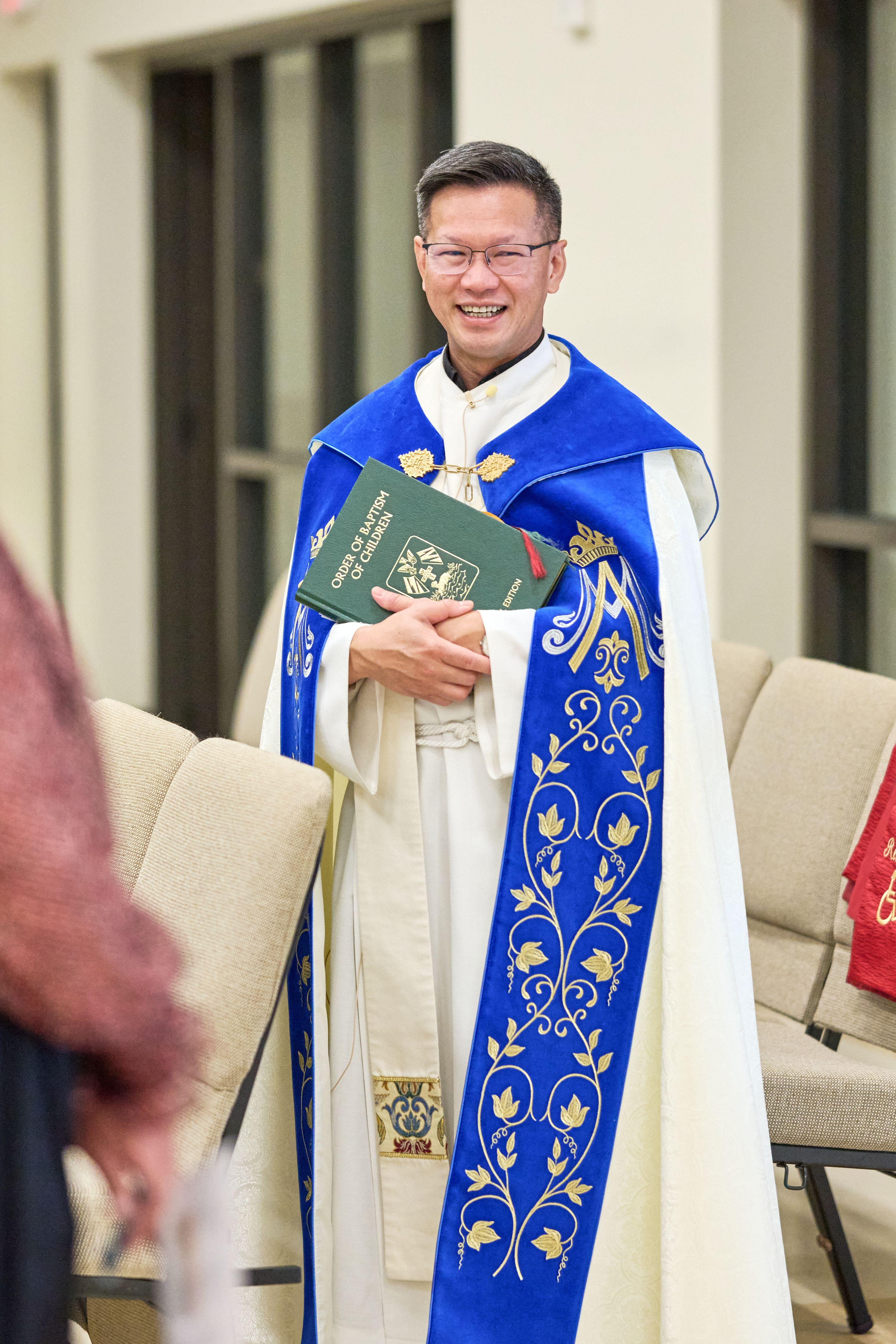 Priest in an embroidered blue and white stole holding a service book — Religious Ceremonies photography, Austin A priest in an embroidered blue and white stole holding a service book.