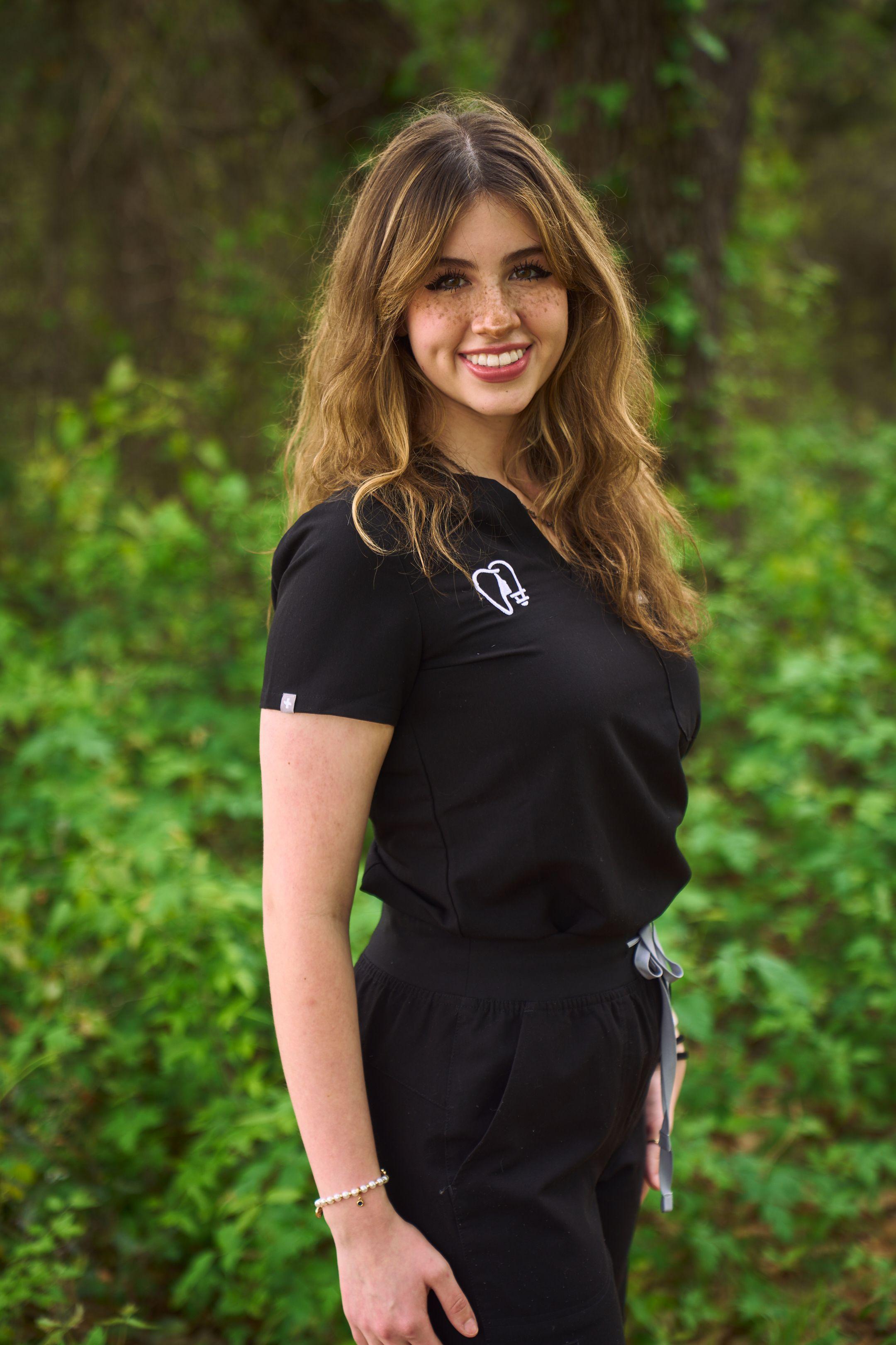 Clinician in a black uniform polo photographed outdoors against dense greenery — Medical team photography, Austin Clinician in a black uniform polo photographed outdoors against dense greenery