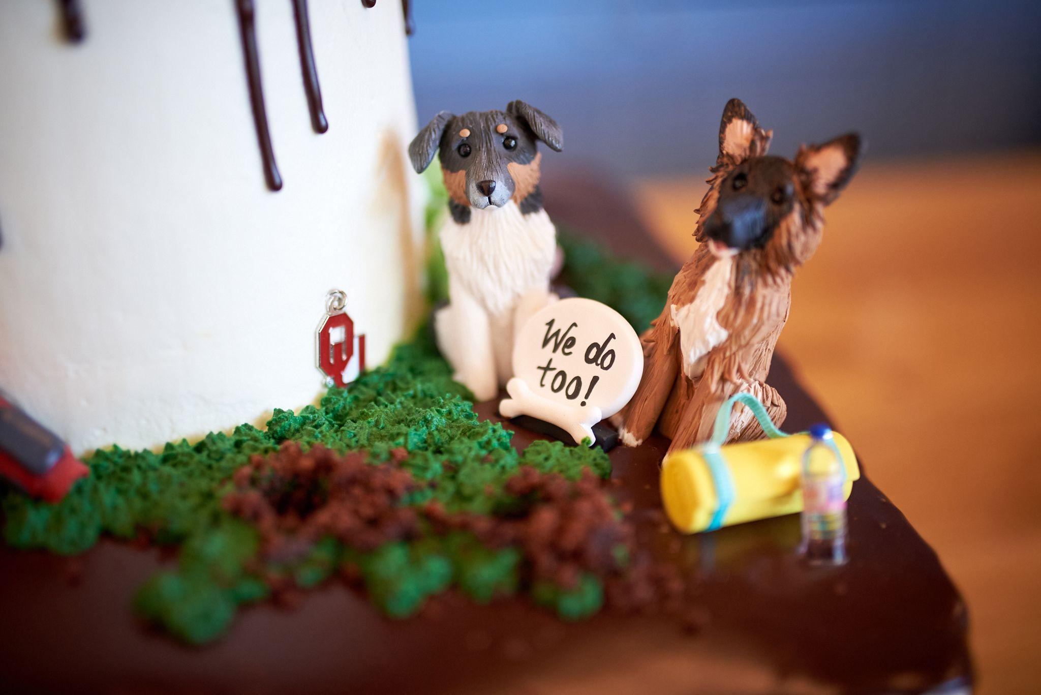 Wedding cake topper of two dogs on grass holding a sign reading 'We do too!' — Weddings photography, Austin A wedding cake topper of two dogs on grass holding a sign reading 'We do too!'
