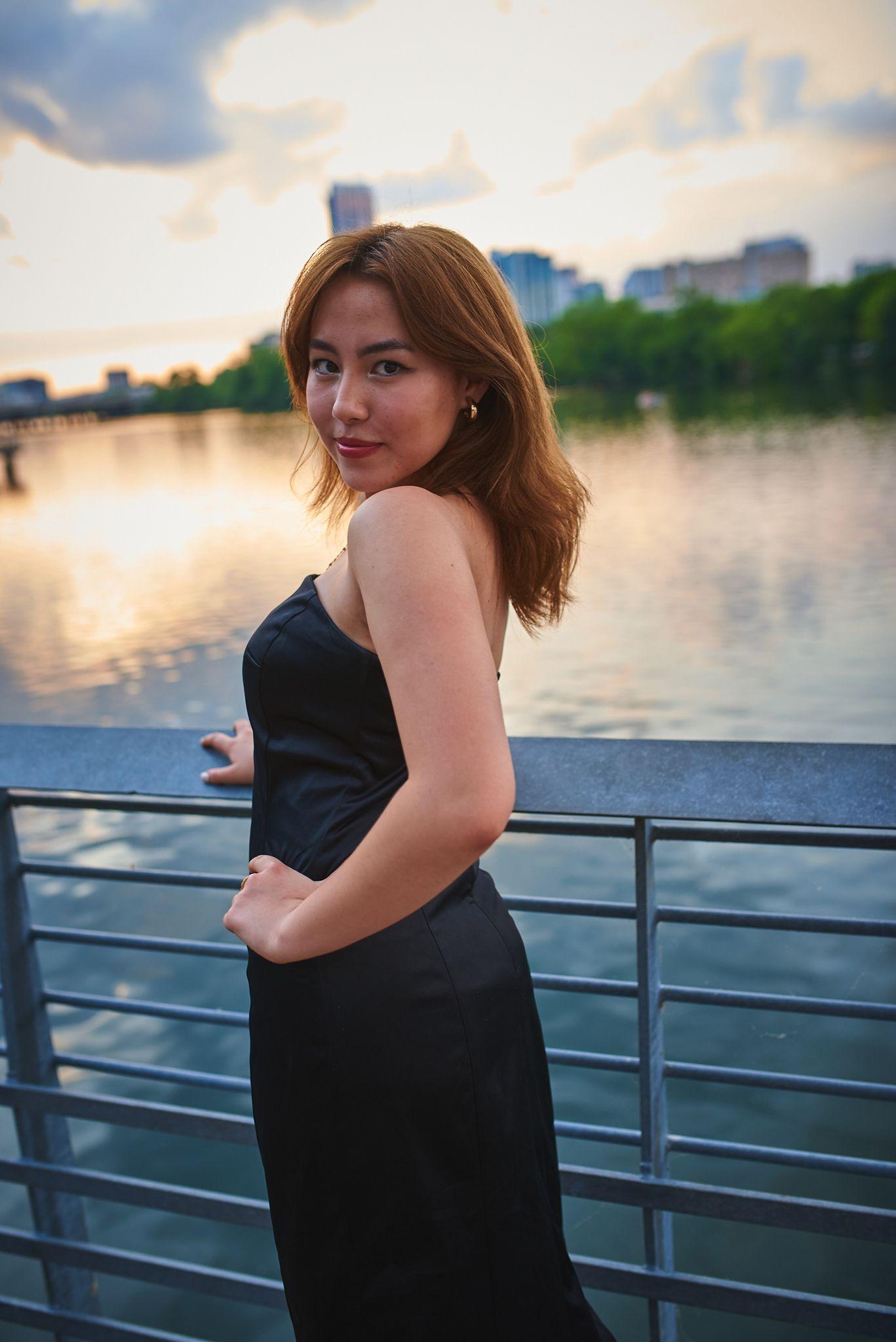 Woman in a black dress at a railing above Lady Bird Lake at golden hour — Austin Boardwalk photography, Austin A woman in a black dress at a railing above Lady Bird Lake at golden hour.