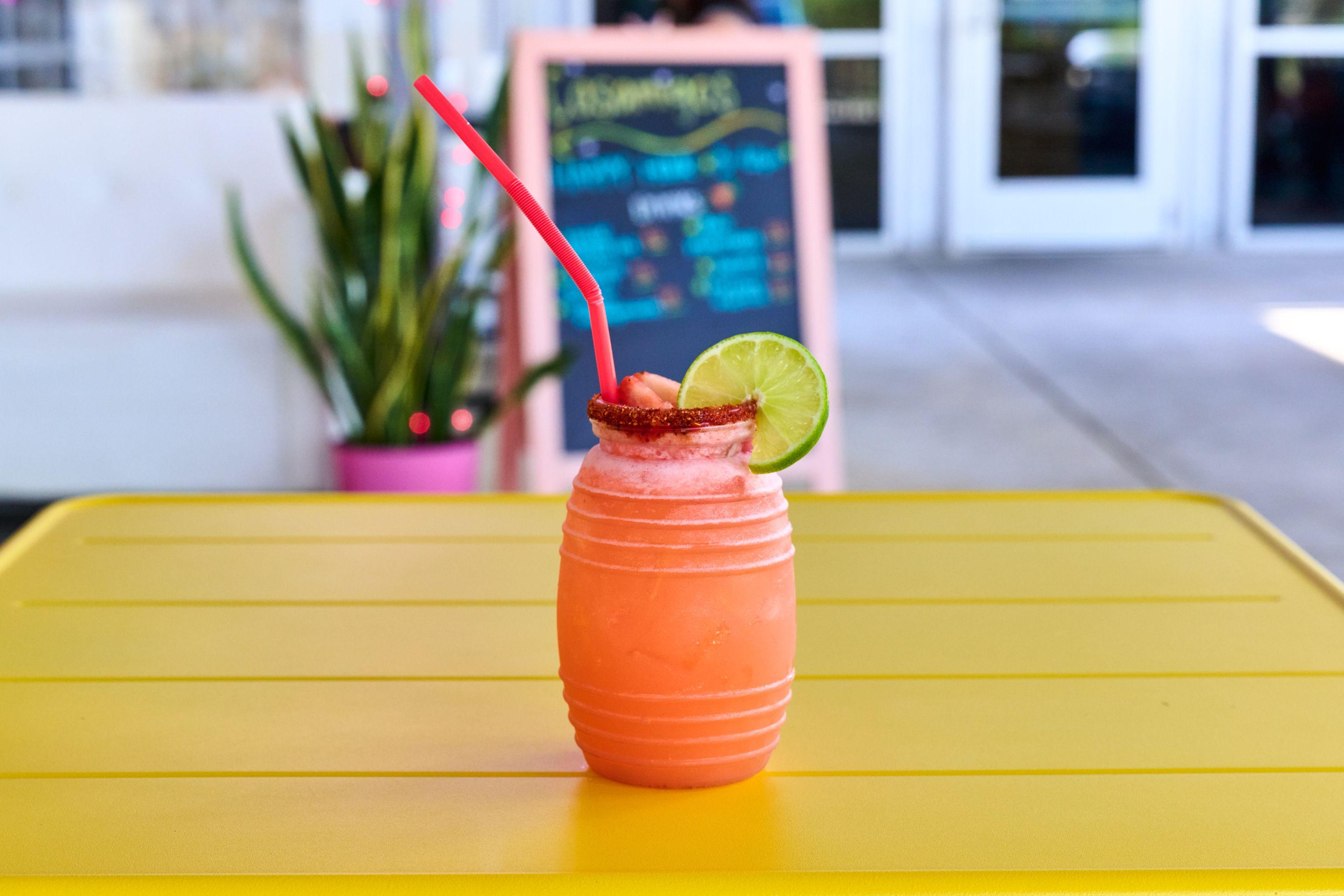 Coral frozen drink with a lime wheel on a bright yellow table — Food & restaurant photography, Austin A coral frozen drink with a lime wheel on a bright yellow table.