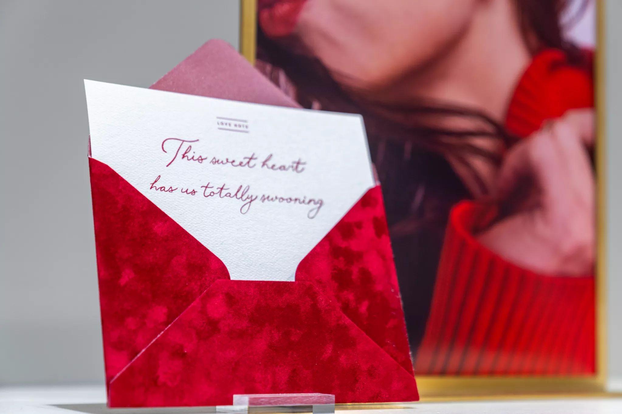 Letterpress card reading "This sweet heart has us totally swooning" tucked — E-commerce & apparel photography, Austin Letterpress card reading "This sweet heart has us totally swooning" tucked into a red patterned envelope