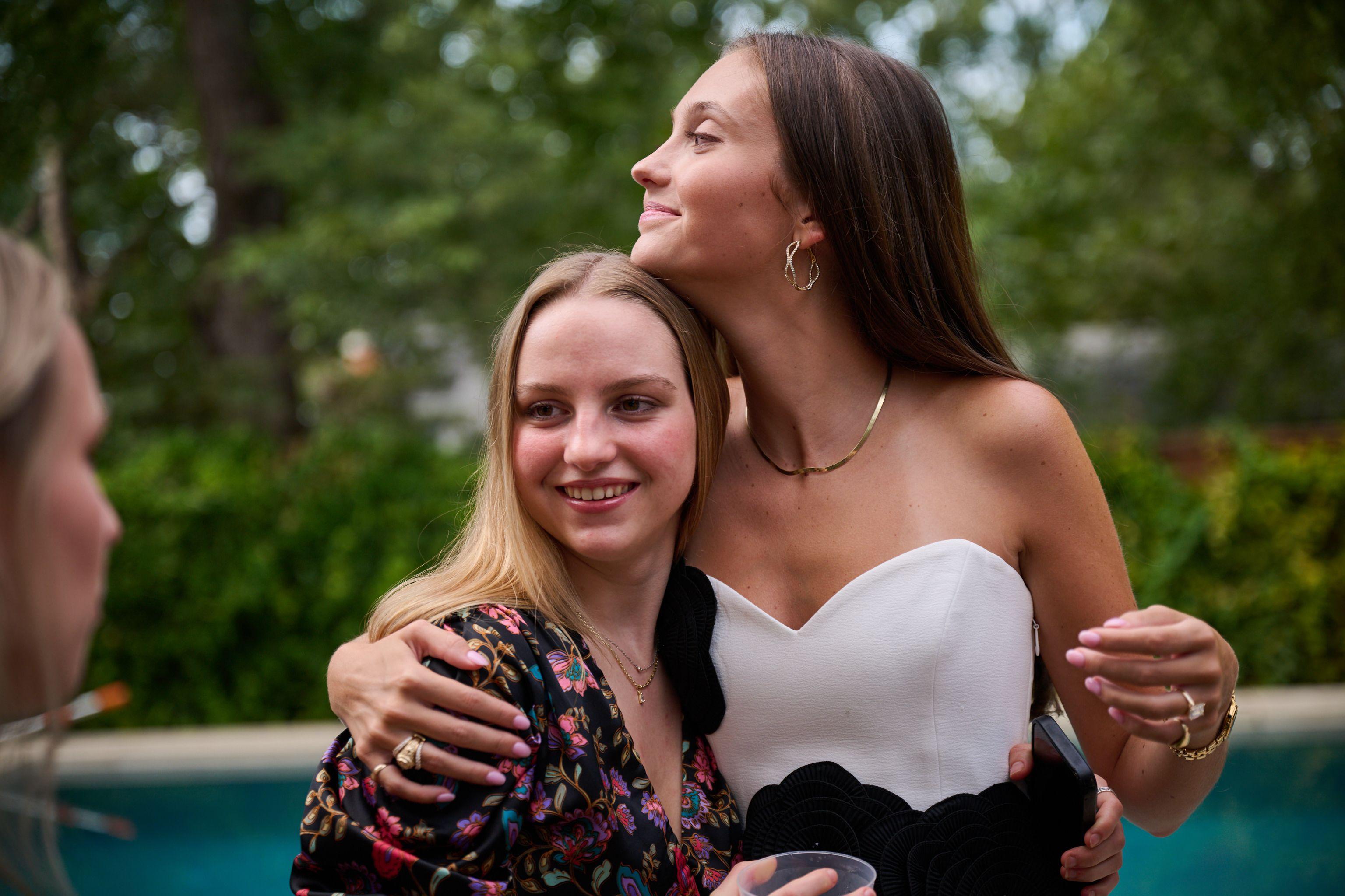 Two friends in party dresses leaning together, one resting her chin on the other's shoulder — Formal Celebrations photography, Austin Two friends in party dresses leaning together, one resting her chin on the other's shoulder.