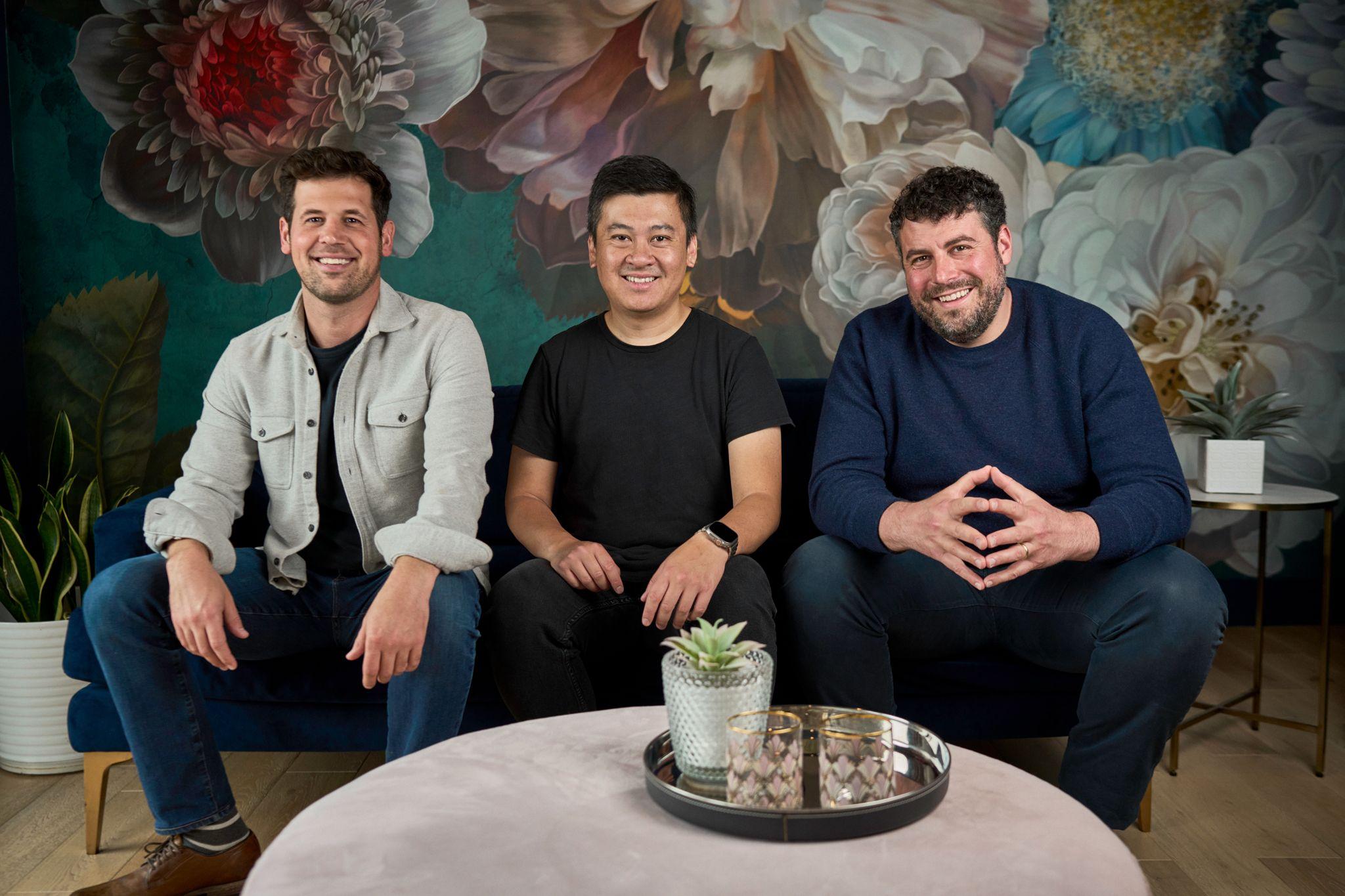 Three men seated and standing around a small table in front of a painted floral backdrop — Commercial photo studio, Austin Commercial Studio