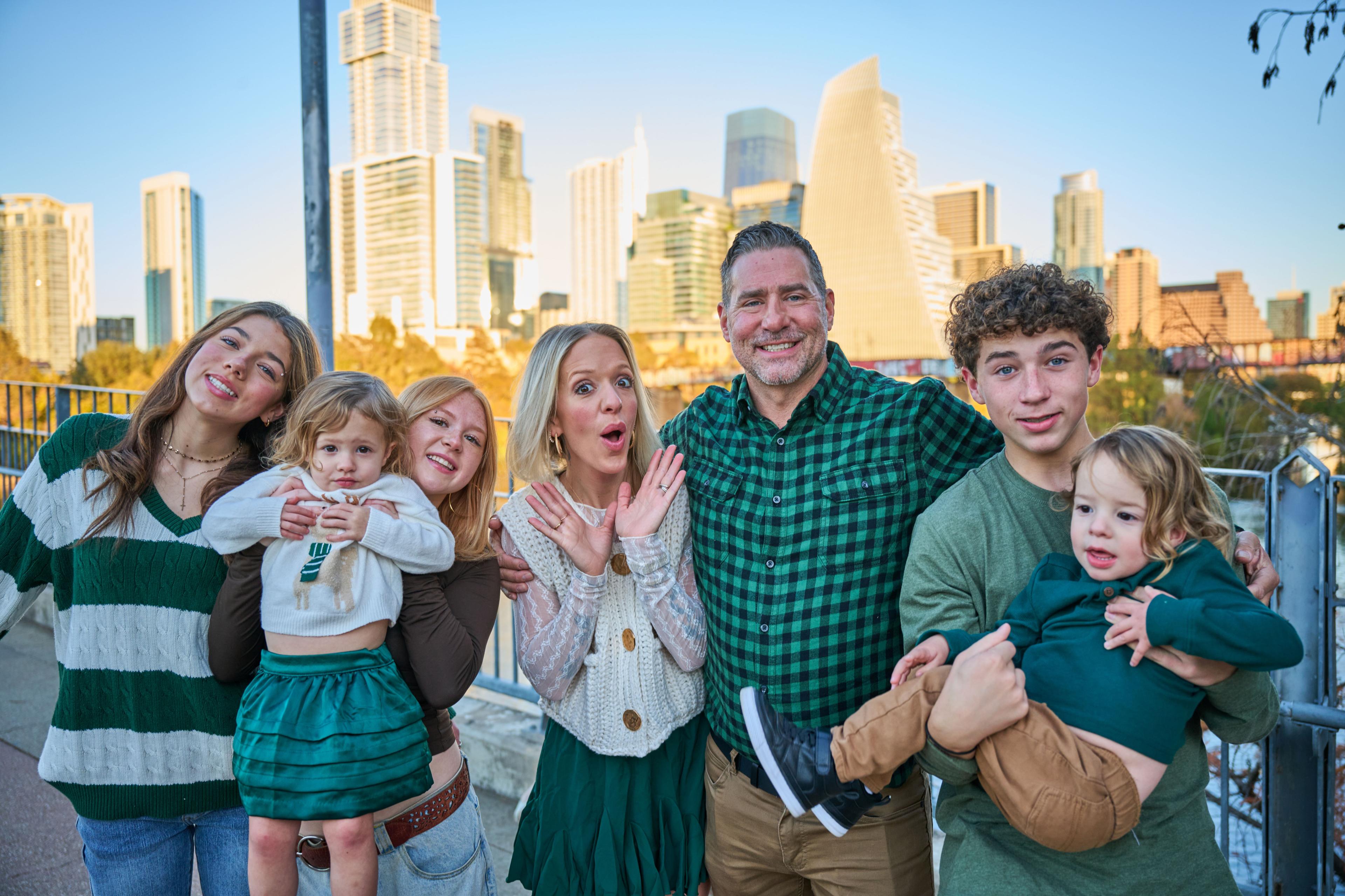 Family of five laughing together at the Pfluger bridge railing, downtown Austin — Pfluger Pedestrian Bridge photography, Austin A family of five laughing together at the Pfluger bridge railing, downtown Austin across the water