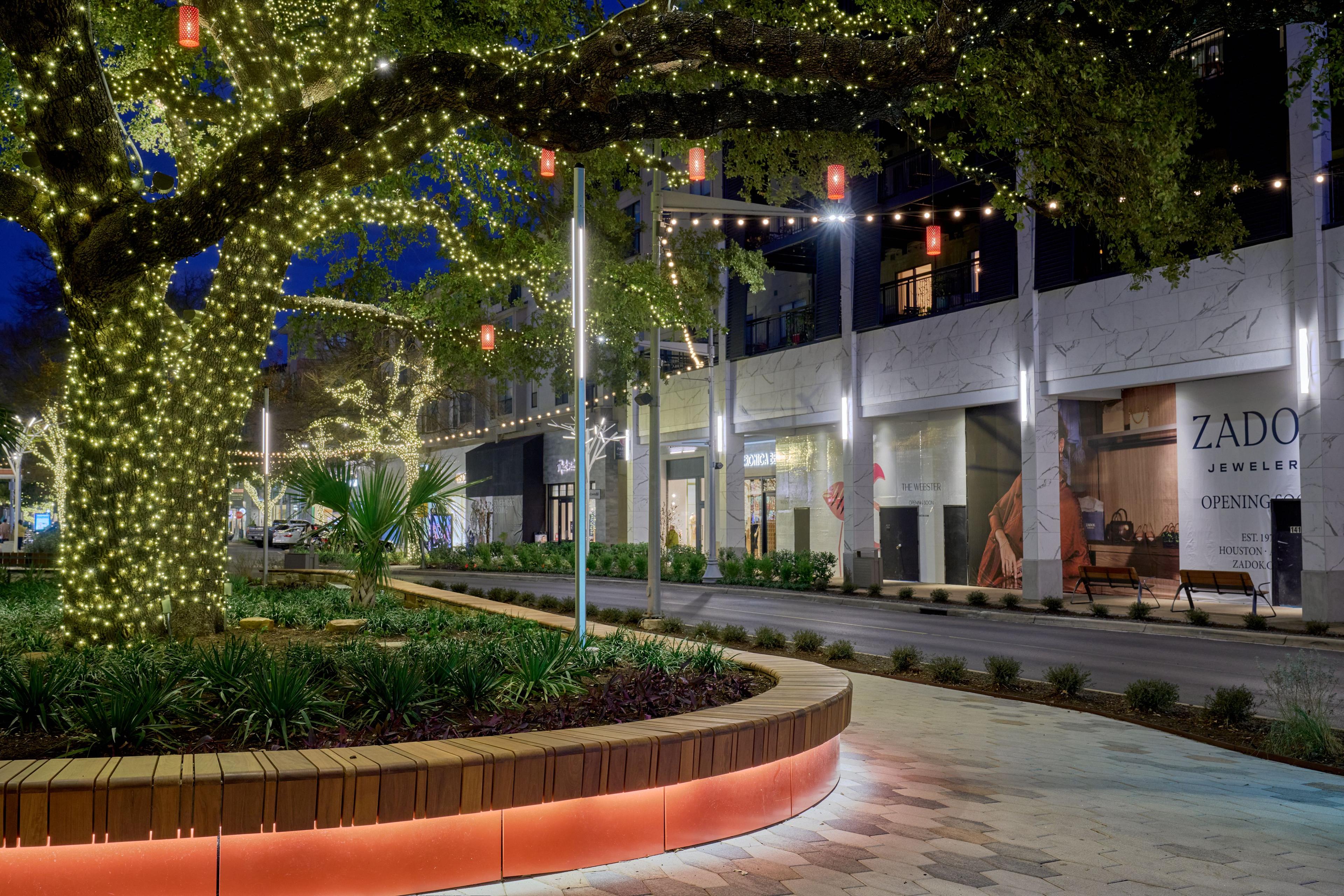Daytime walkway through The Domain, planted beds with orange edging running — The Domain photography, Austin A daytime walkway through The Domain, planted beds with orange edging running between the storefronts
