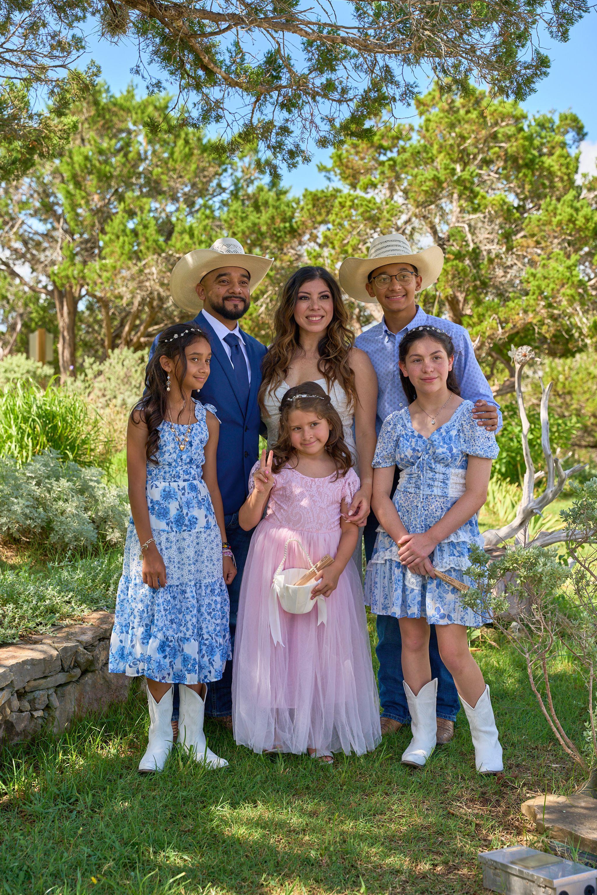 Family with children in blue and pink among the trees beside Chapel Dulcinea — Chapel Dulcinea photography, Austin A family with children in blue and pink among the trees beside Chapel Dulcinea