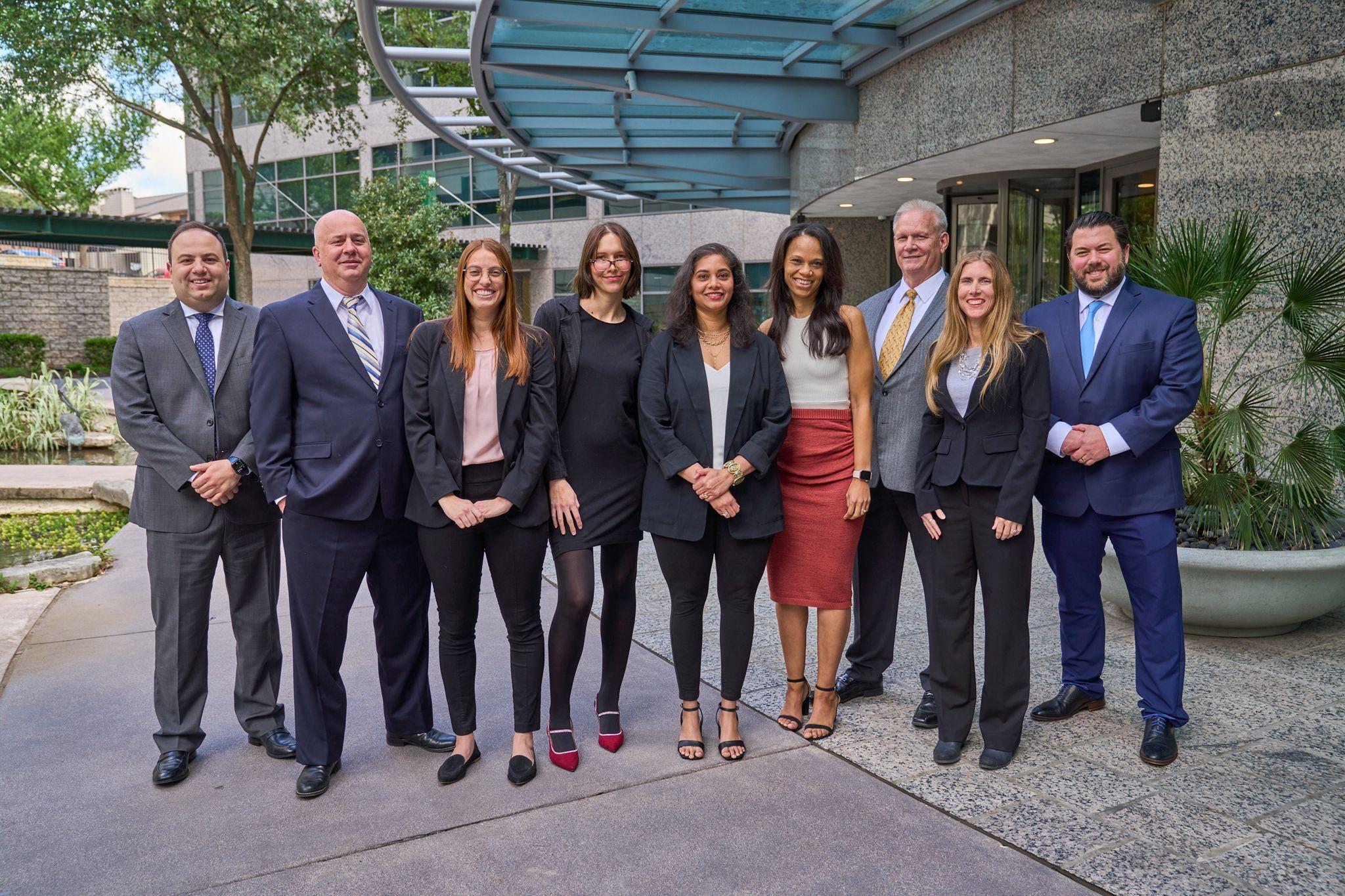 Line-up of about ten colleagues in business dress standing shoulder to shoulder outdoors — Team photography, Austin Line-up of about ten colleagues in business dress standing shoulder to shoulder outdoors