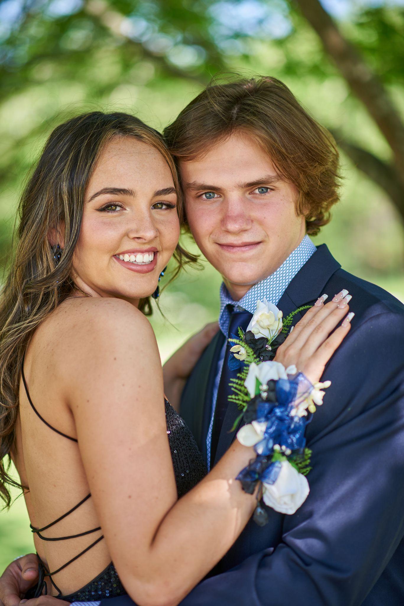 Prom couple posed together, his boutonnière and her corsage in blue and white — Graduation & Prom photography, Austin A prom couple posed together, his boutonnière and her corsage in blue and white.