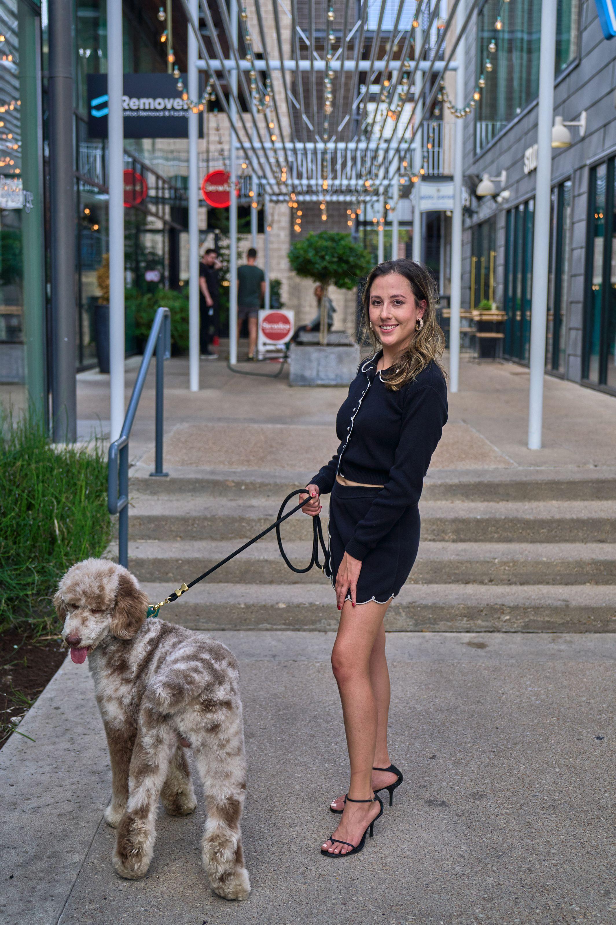 Woman with her dog on a South Congress pavement under string lights — South Congress (SoCo) photography, Austin A woman with her dog on a South Congress pavement under string lights.