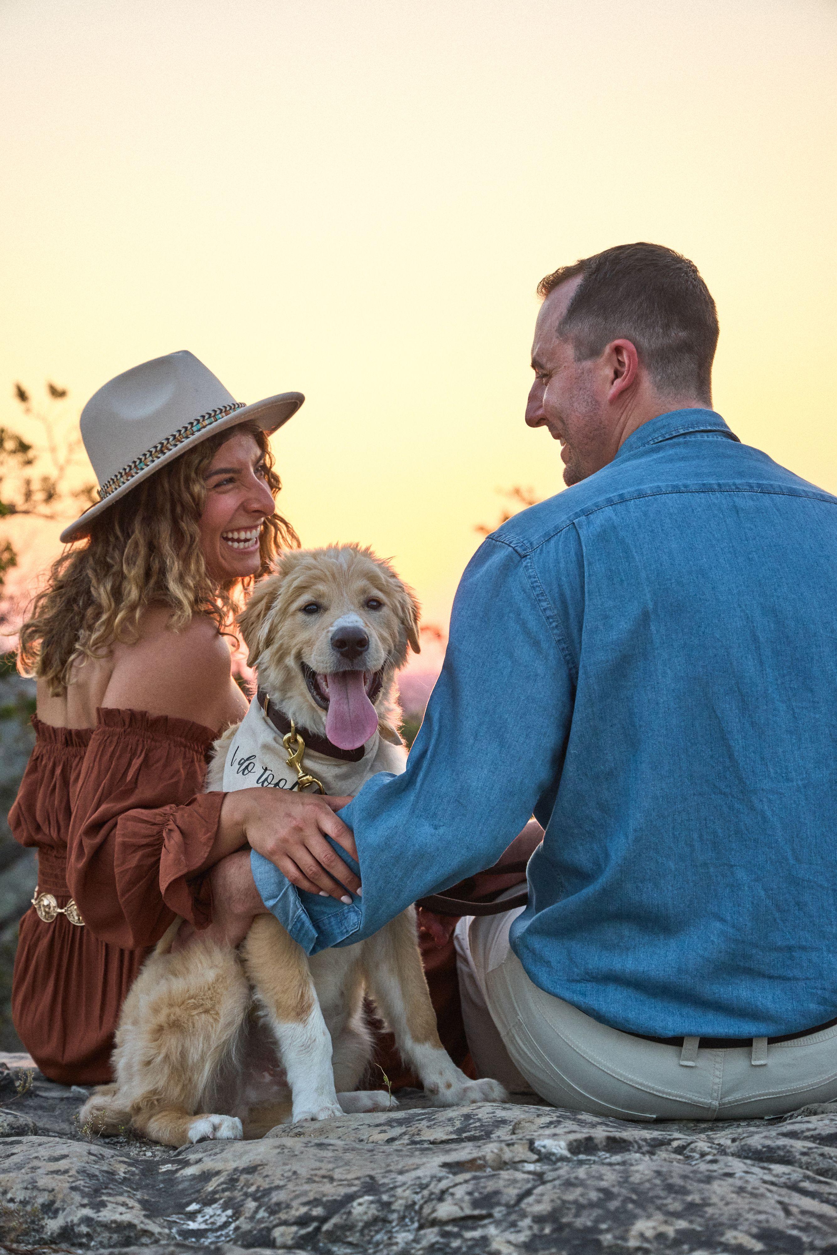 Couple on the rock with their golden retriever, hill country and evening sky behind them — Wimberley TX photography, Austin A couple on the rock with their golden retriever, hill country and evening sky behind them