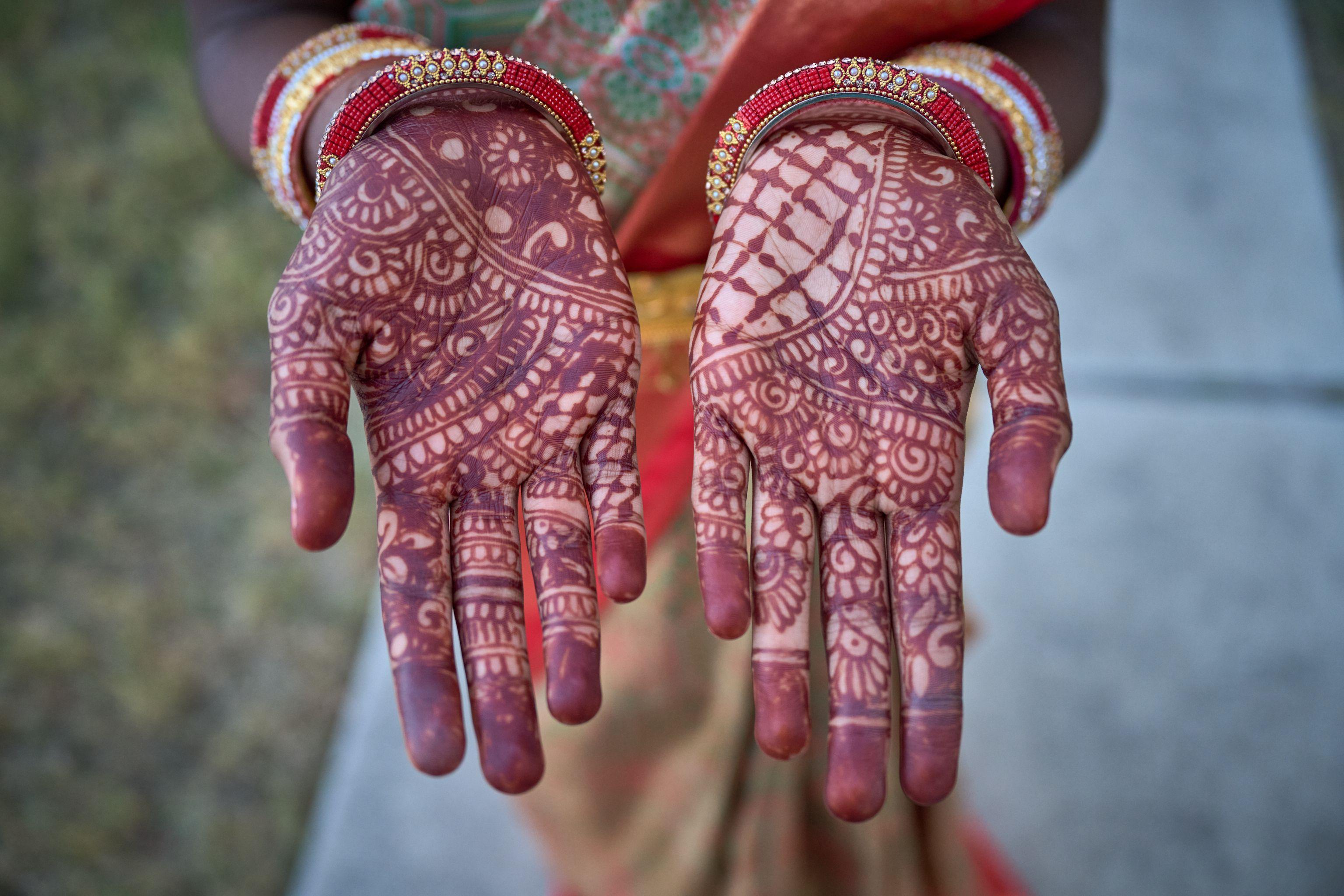 Two open palms covered in intricate deep red mehndi patterns — Religious Ceremonies photography, Austin Two open palms covered in intricate deep red mehndi patterns.