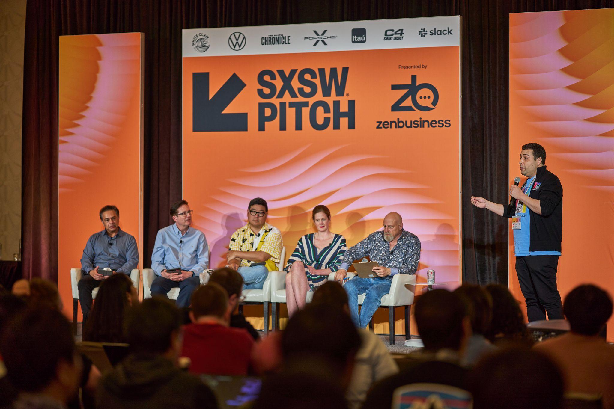 Five panelists seated in front of the orange SXSW Pitch and ZenBusiness sponsor wall — Conventions & Tradeshows photography, Austin Five panelists seated in front of the orange SXSW Pitch and ZenBusiness sponsor wall.