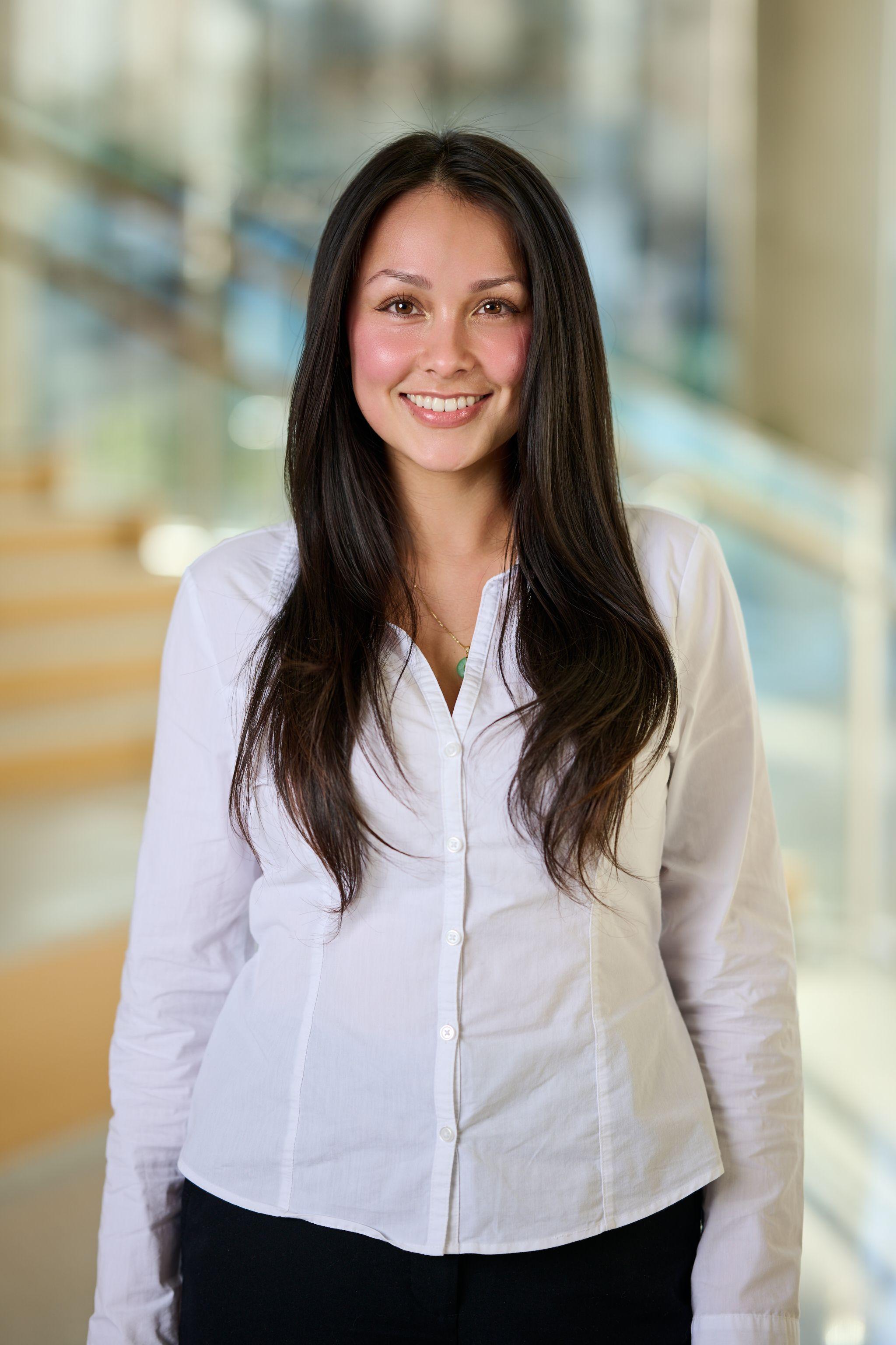 Woman with long dark hair in a white button shirt, photographed in an office atrium — Business headshots, Austin A woman with long dark hair in a white button shirt, photographed in an office atrium