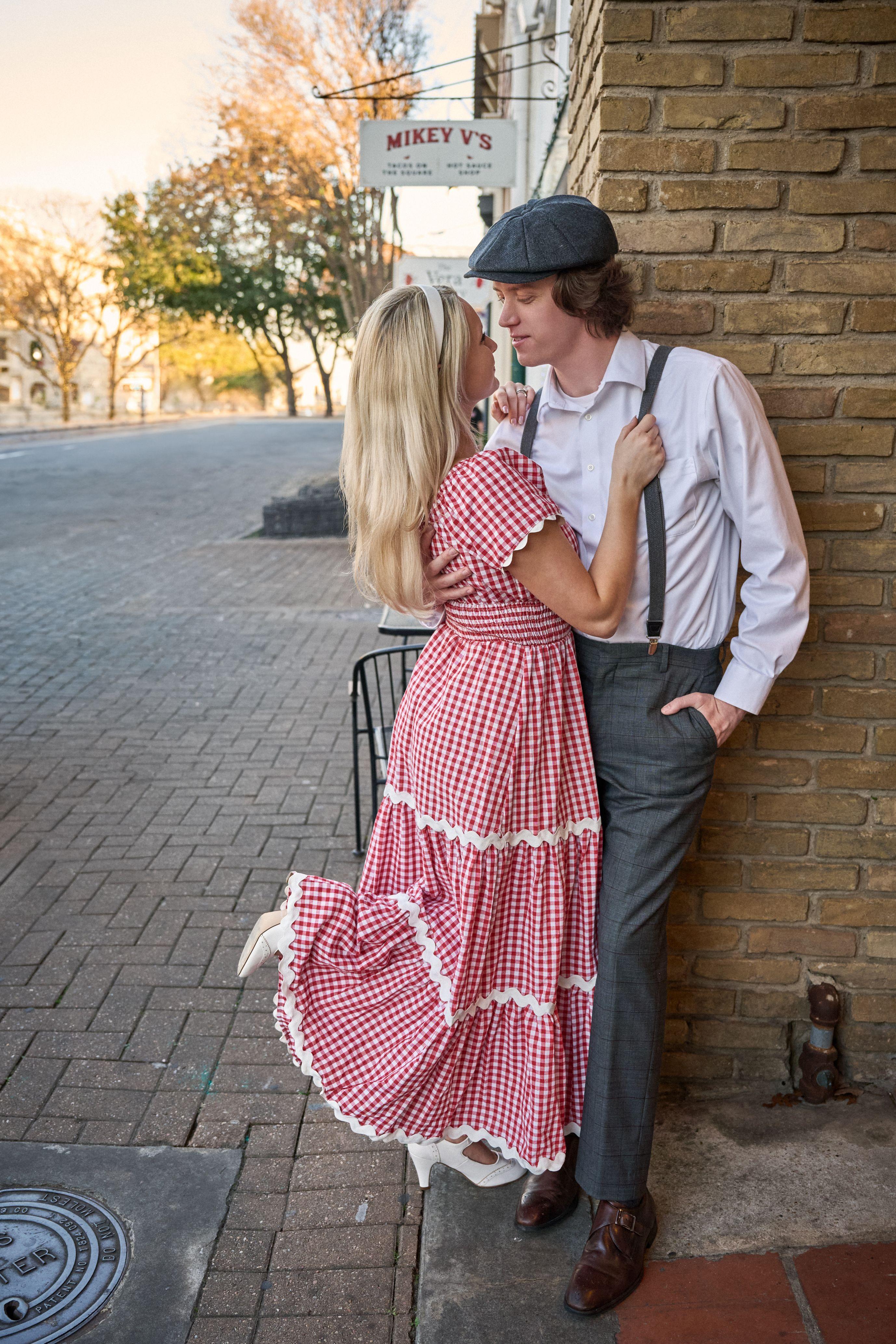 1940s-styled couple in a red gingham dress and suspenders on a brick street — Couples & Anniversary photography, Austin A 1940s-styled couple in a red gingham dress and suspenders on a brick street.