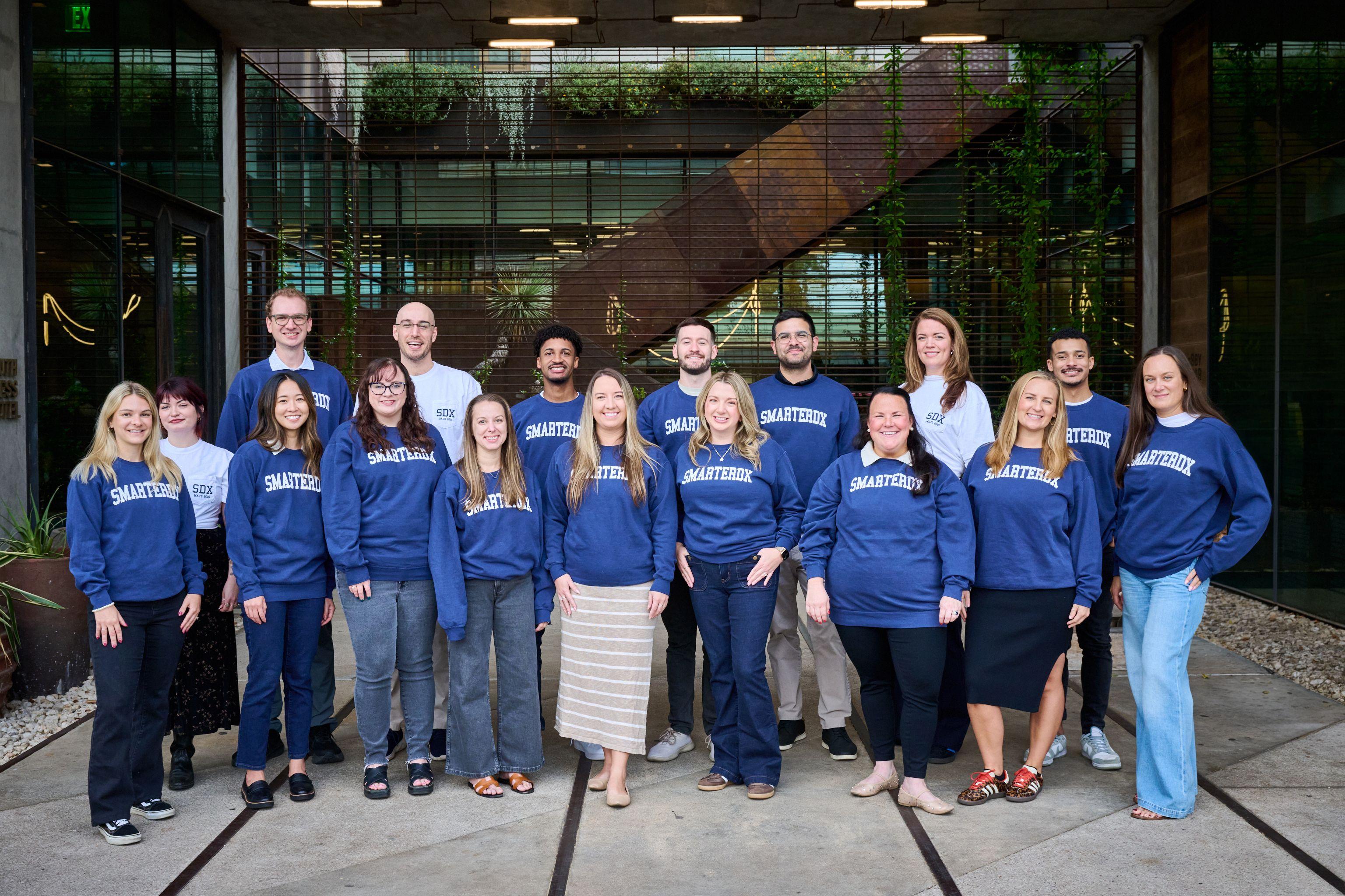 Team in matching blue sweatshirts posed together outdoors — South Congress (SoCo) photography, Austin Team in matching blue sweatshirts posed together outdoors