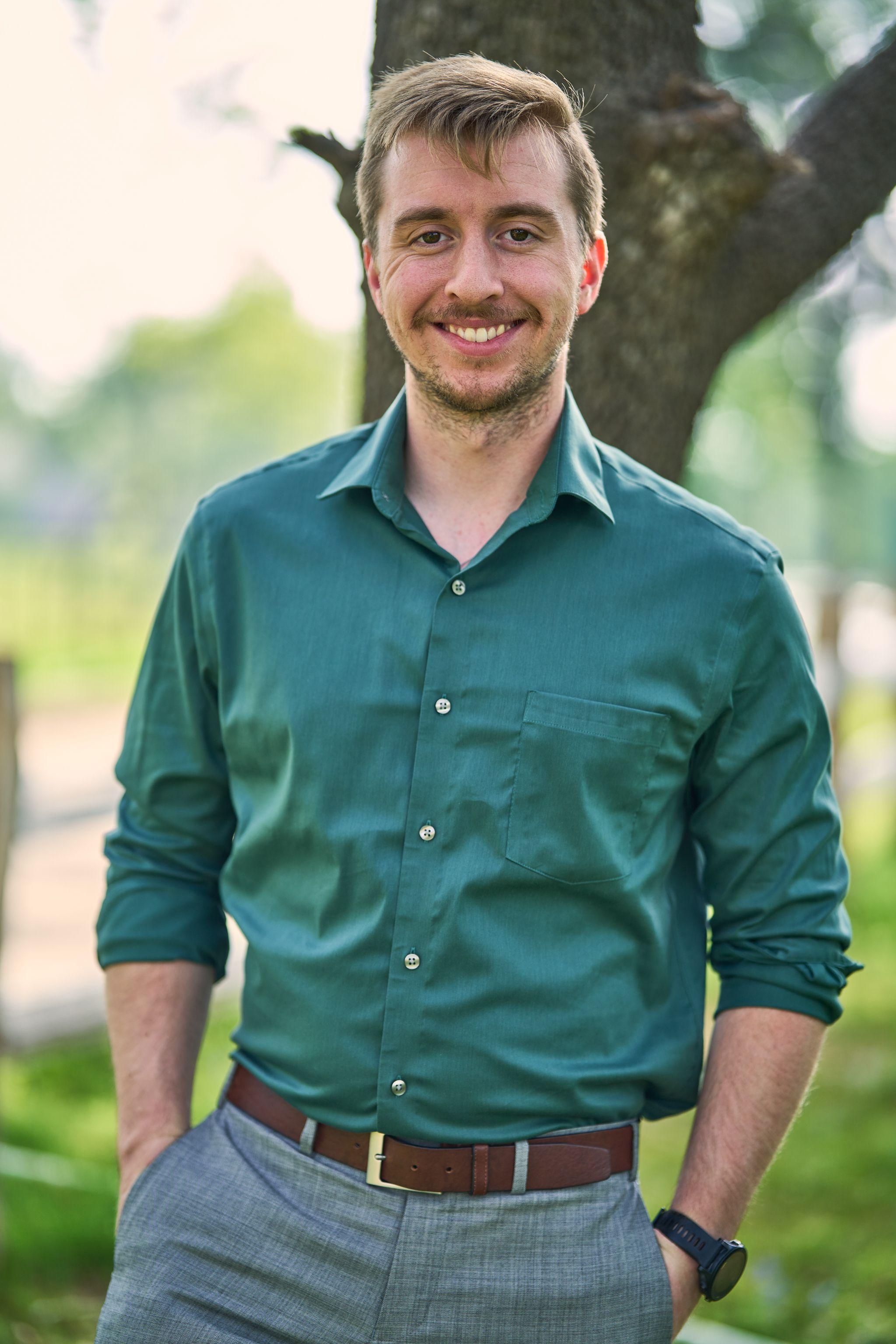 Man in a green shirt with his sleeves rolled, hands in his pockets — Cedar Park Public Library photography, Austin A man in a green shirt with his sleeves rolled, hands in his pockets, on the Cedar Park library lawn