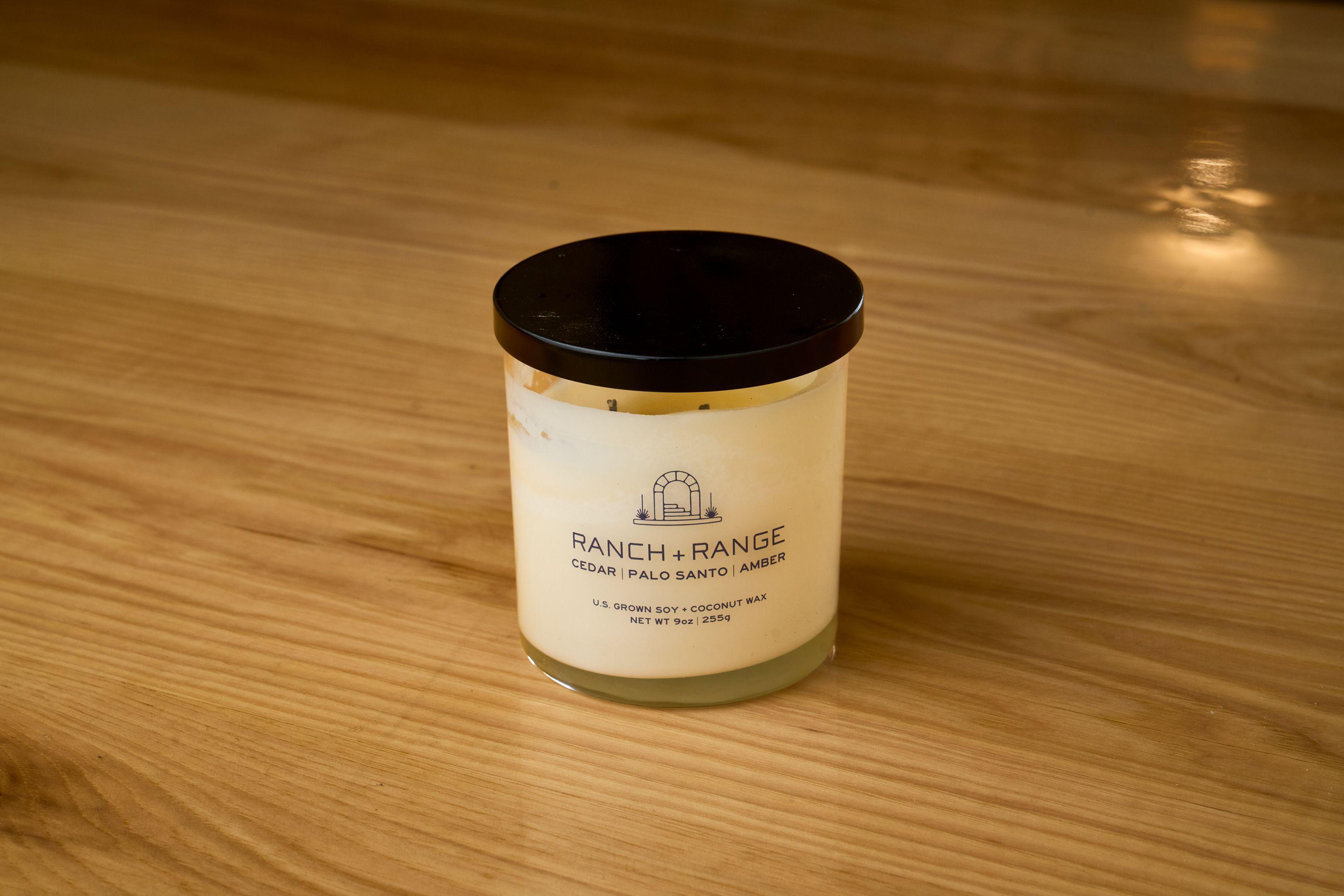 Ranch + Range branded candle in a glass jar on a wooden surface — Product photography, Austin A Ranch + Range branded candle in a glass jar on a wooden surface.
