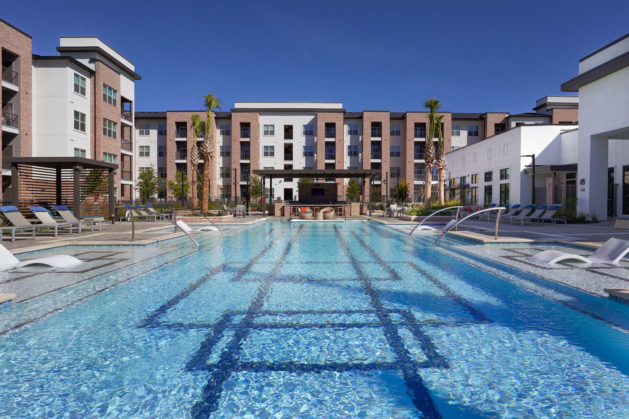 Resort-style swimming pool with lane markings on an apartment amenity deck — Architectural photography, Austin A resort-style swimming pool with lane markings on an apartment amenity deck.