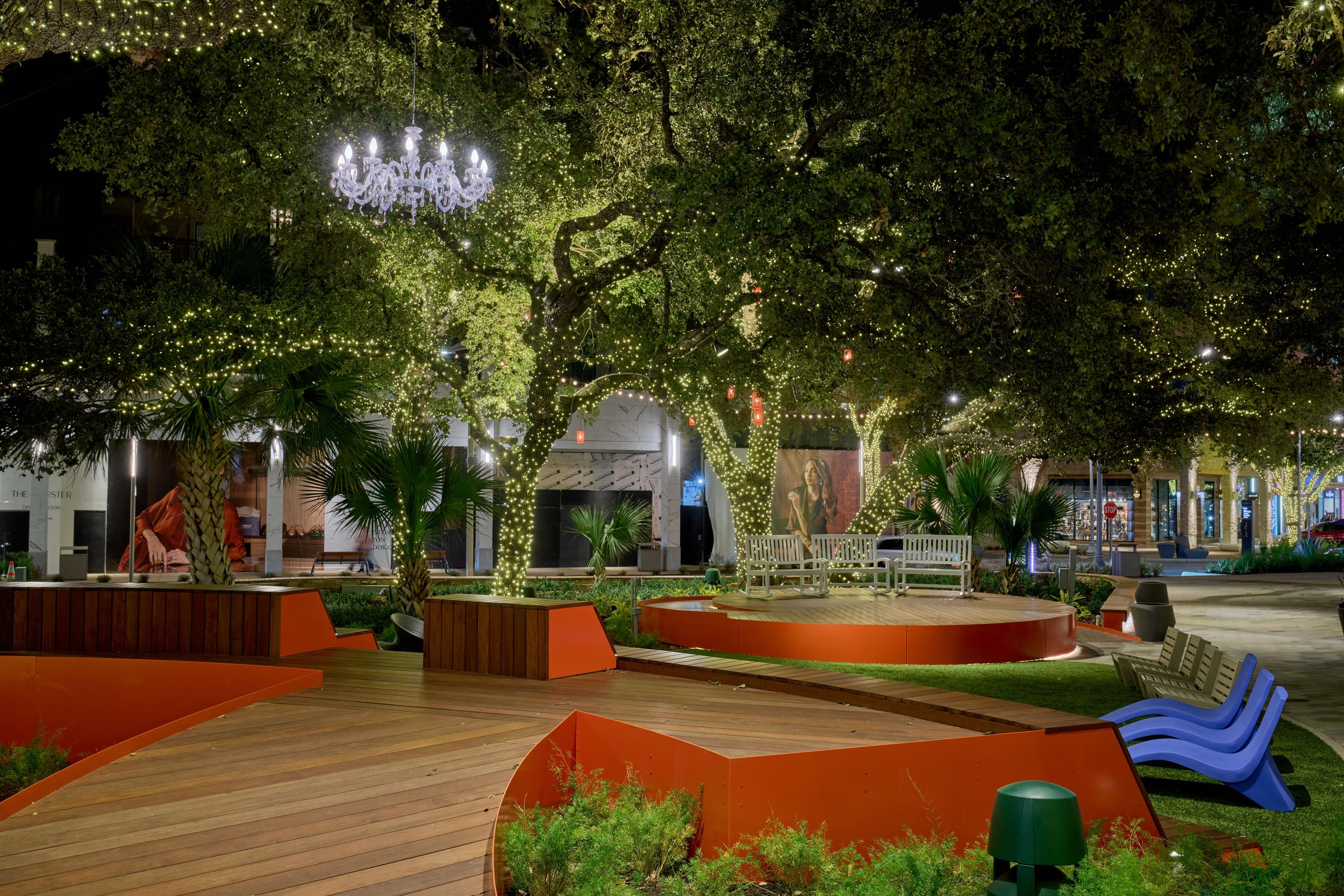 Amenity courtyard at blue hour with a chandelier hanging from an oak tree — Architectural photography, Austin An amenity courtyard at blue hour with a chandelier hanging from an oak tree.