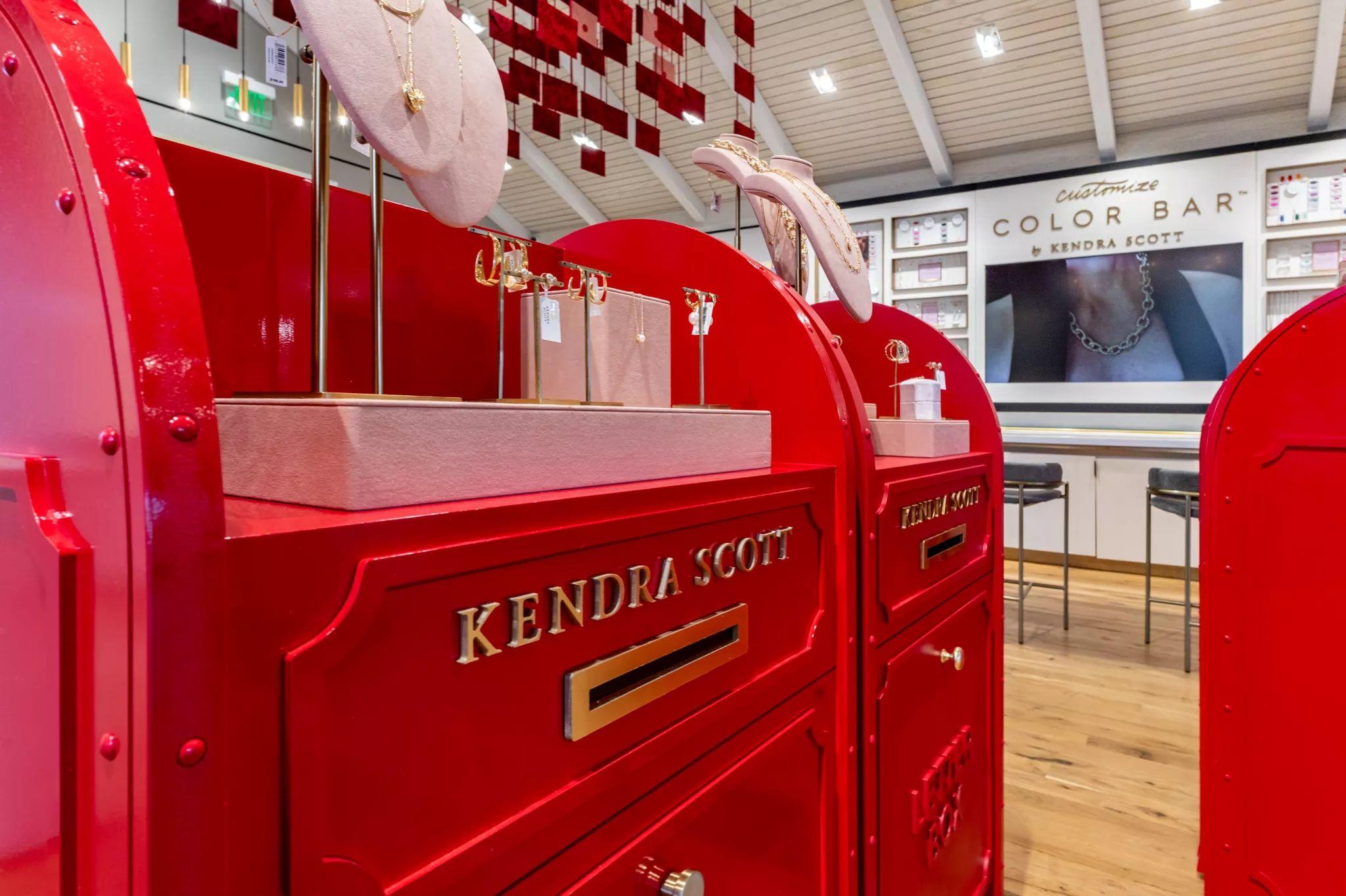Oversized red Kendra Scott mailbox display inside a store, with jewelry and glassware — E-commerce & apparel photography, Austin Oversized red Kendra Scott mailbox display inside a store, with jewelry and glassware on the counter above