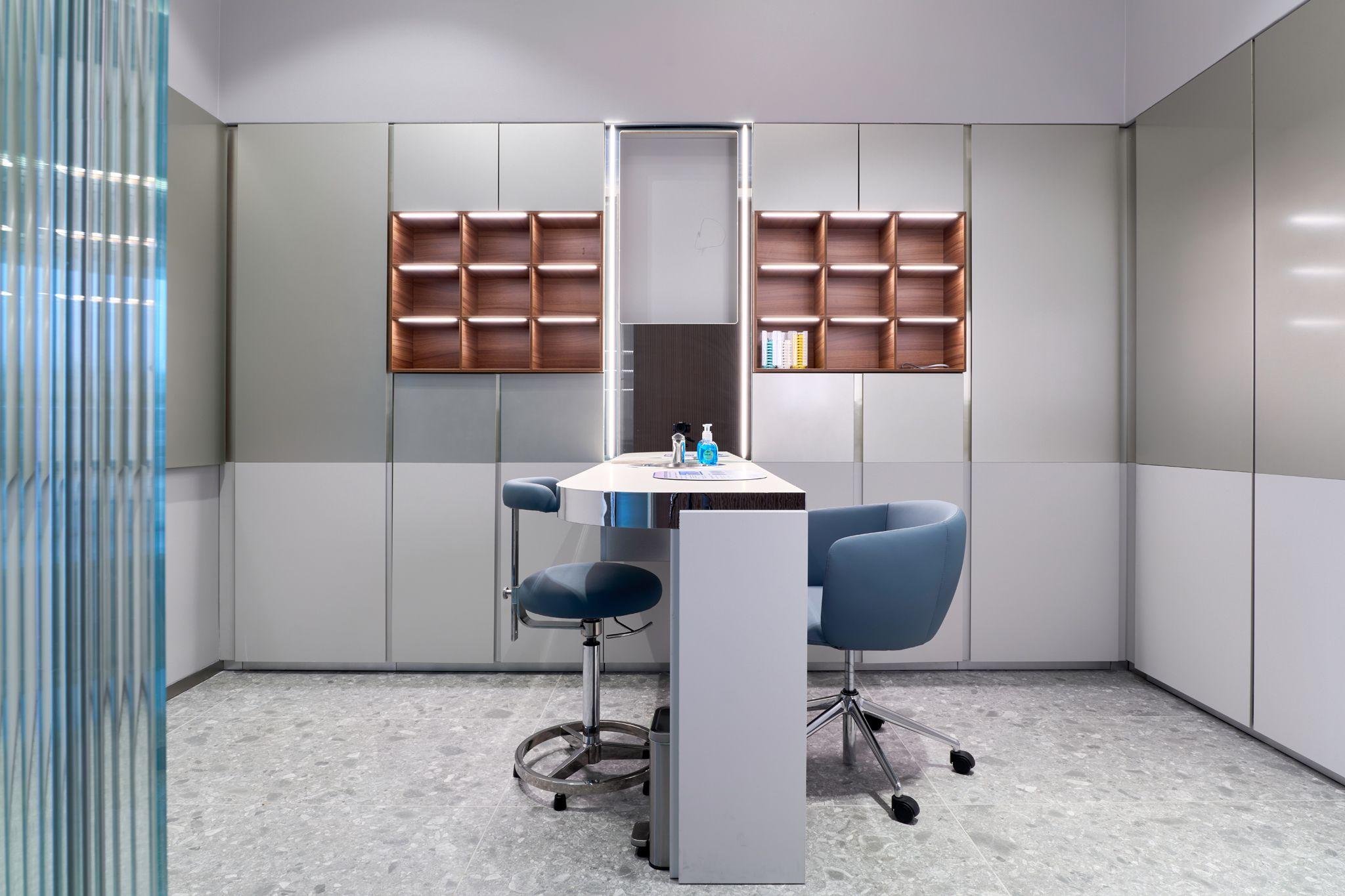 Empty treatment room with a stool, chairs and a wall of copper-fronted cabinets — Medical team photography, Austin Empty treatment room with a stool, chairs and a wall of copper-fronted cabinets