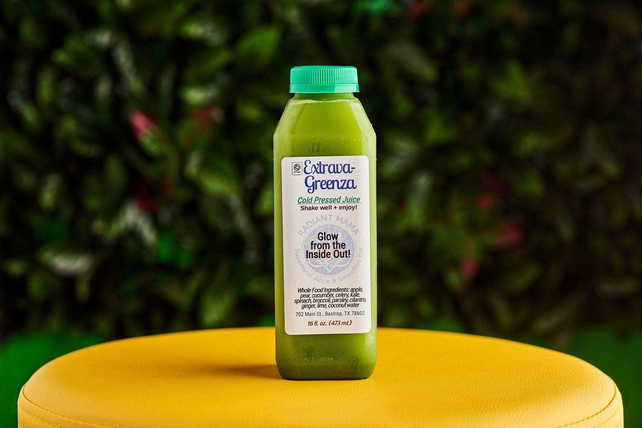 Bottle of Extrava-Greenza cold-pressed green juice standing on a yellow table — E-commerce & apparel photography, Austin Bottle of Extrava-Greenza cold-pressed green juice standing on a yellow table in front of foliage