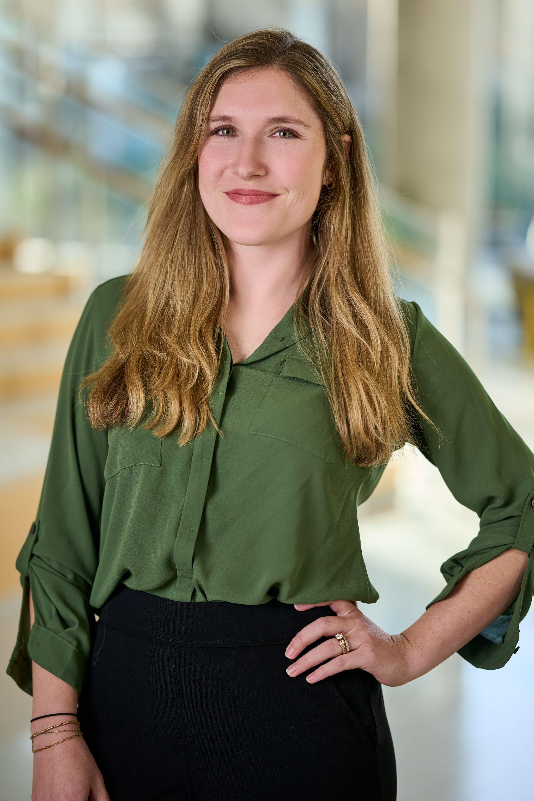 Woman in a green blouse with one hand on her hip, photographed in a bright office atrium — Mobile photo studio, Austin A woman in a green blouse with one hand on her hip, photographed in a bright office atrium