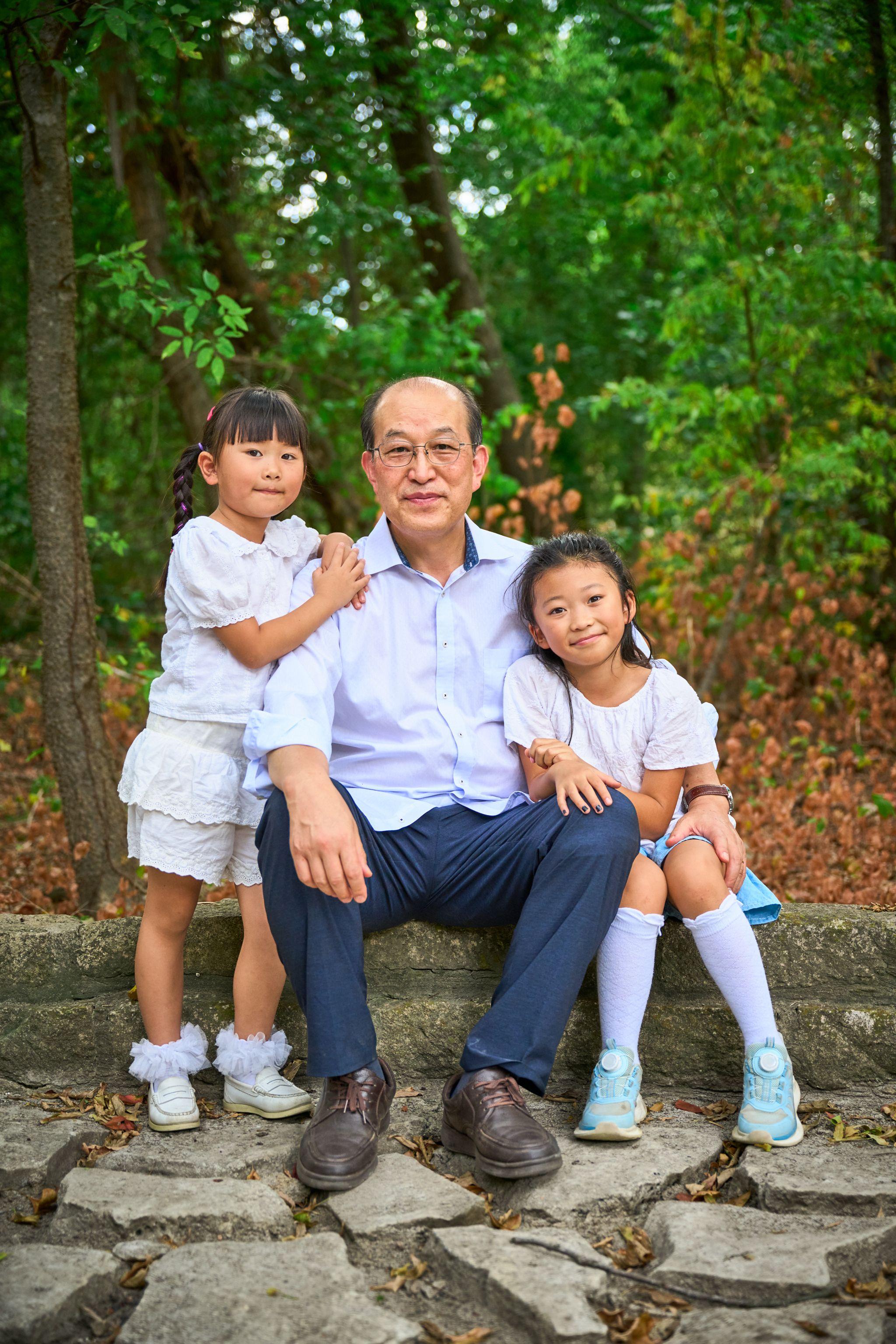 Grandfather seated on a bench at Mills Pond with three grandchildren gathered around him — Mills Pond photography, Austin A grandfather seated on a bench at Mills Pond with three grandchildren gathered around him