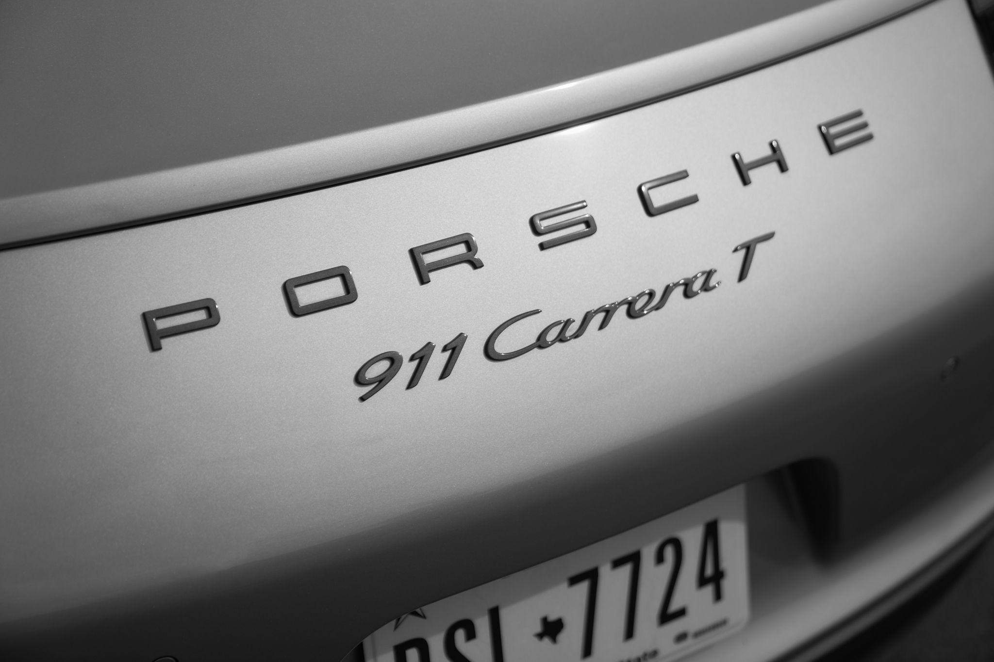 Close detail of the 911 Carrera badge on a silver Porsche — Product photography, Austin A close detail of the 911 Carrera badge on a silver Porsche.
