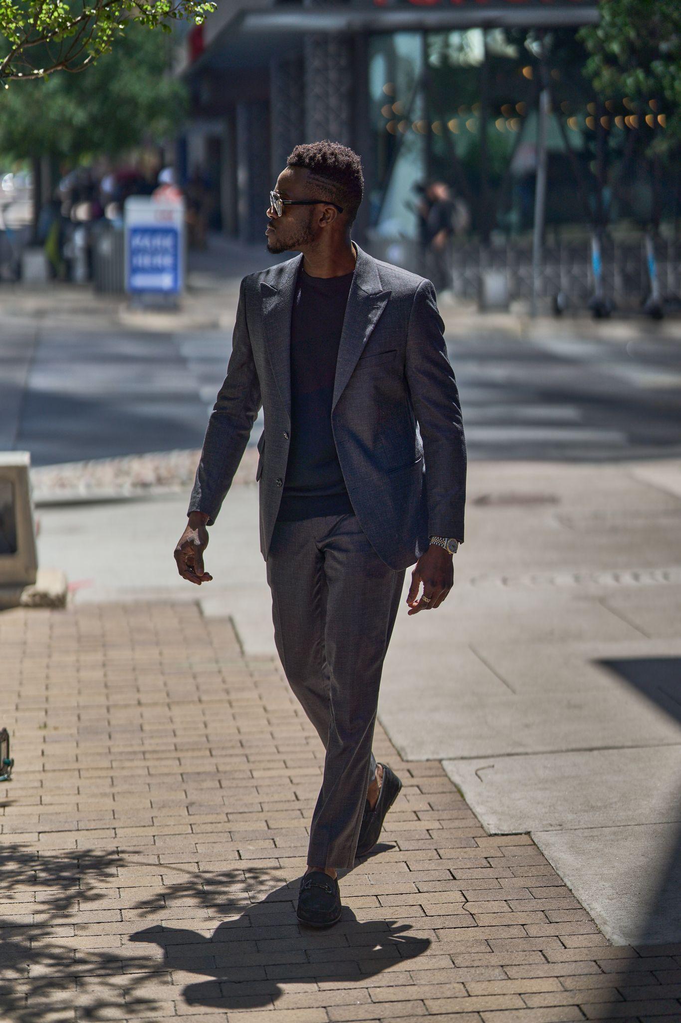 Man in a suit walking along a downtown sidewalk — Downtown Austin photography, Austin A man in a suit walking along a downtown sidewalk.