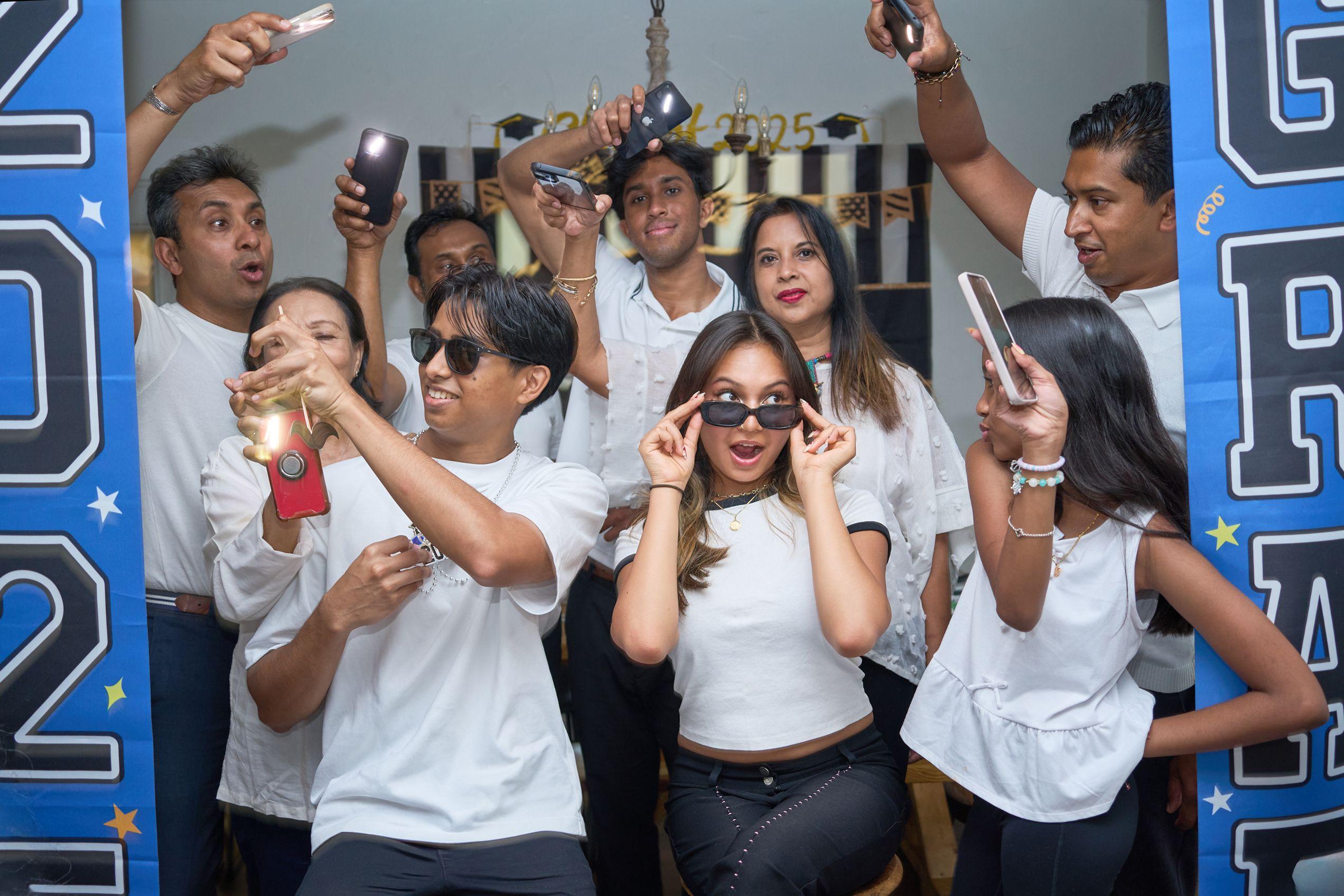 Friends in white shirts posing with props and phones at a graduation celebration — Graduation & Prom photography, Austin Friends in white shirts posing with props and phones at a graduation celebration.