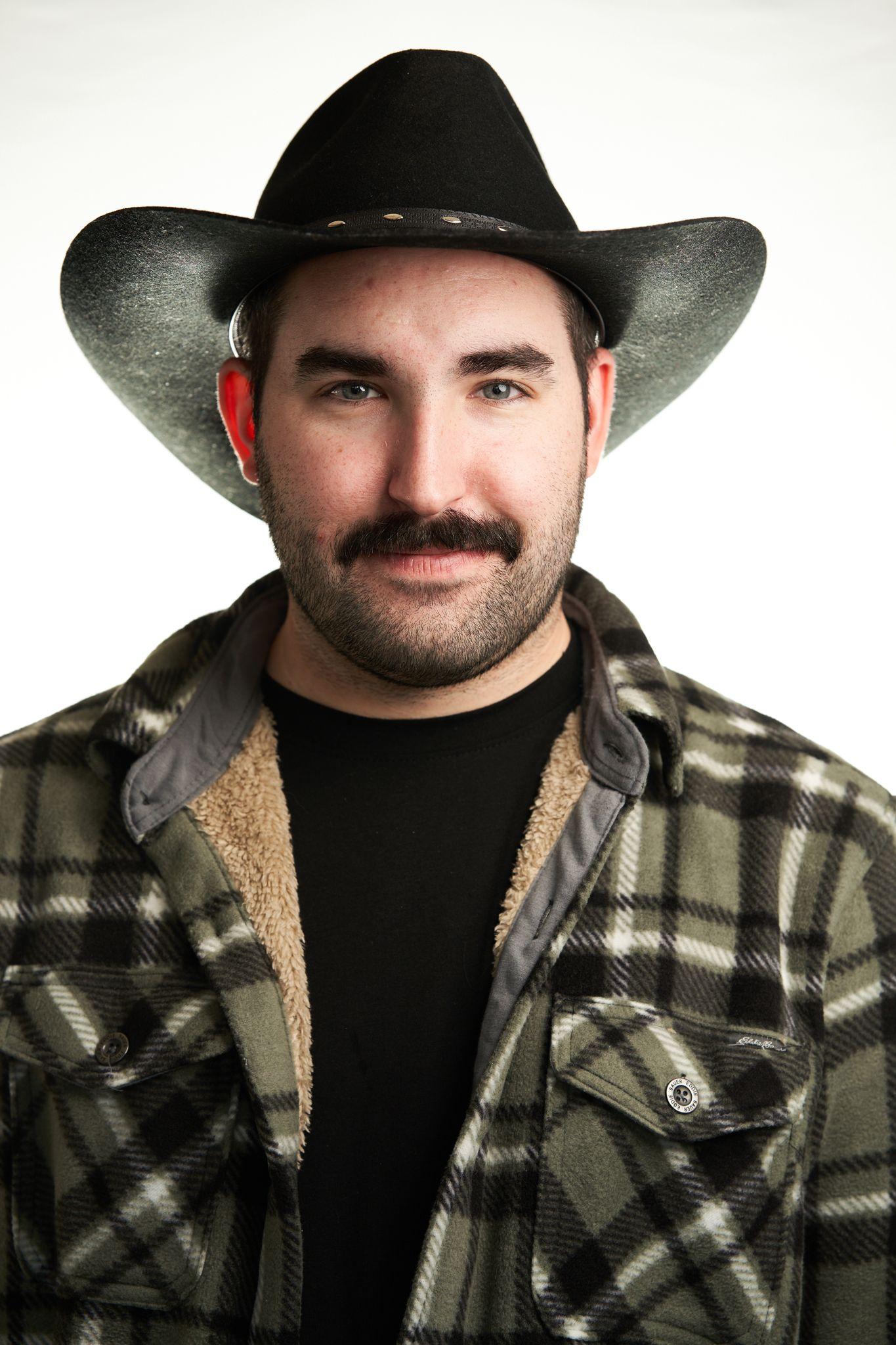 Man in a black cowboy hat and plaid jacket against a white studio backdrop — Headshot photography, Austin A man in a black cowboy hat and plaid jacket against a white studio backdrop.