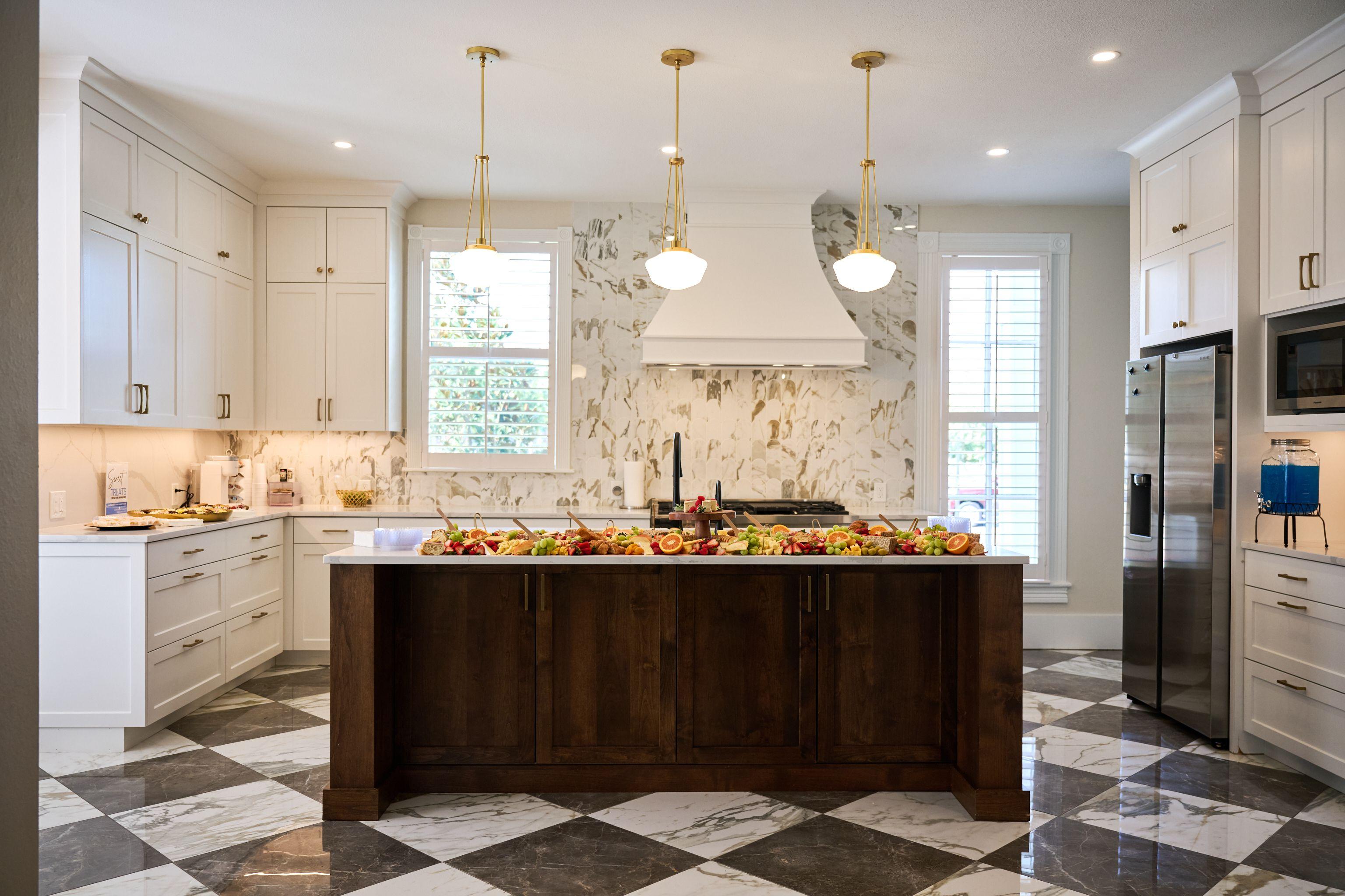 Residential kitchen with a marble backsplash, brass pendants and a dark wood island — Architectural photography, Austin A residential kitchen with a marble backsplash, brass pendants and a dark wood island.