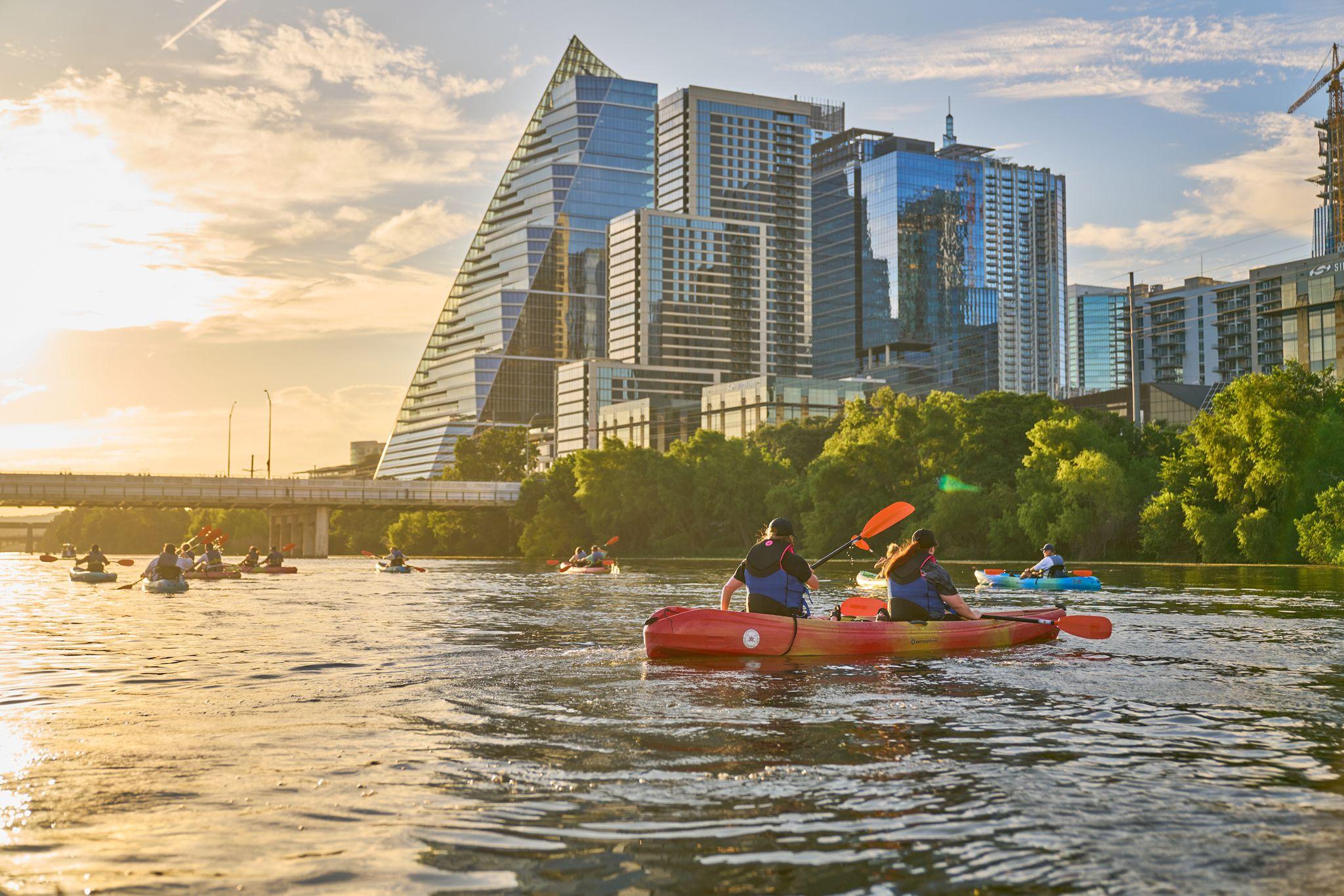 Kayakers paddling on the lake with the downtown Austin skyline behind them — Adventure & outdoor photography, Austin Kayakers paddling on the lake with the downtown Austin skyline behind them.