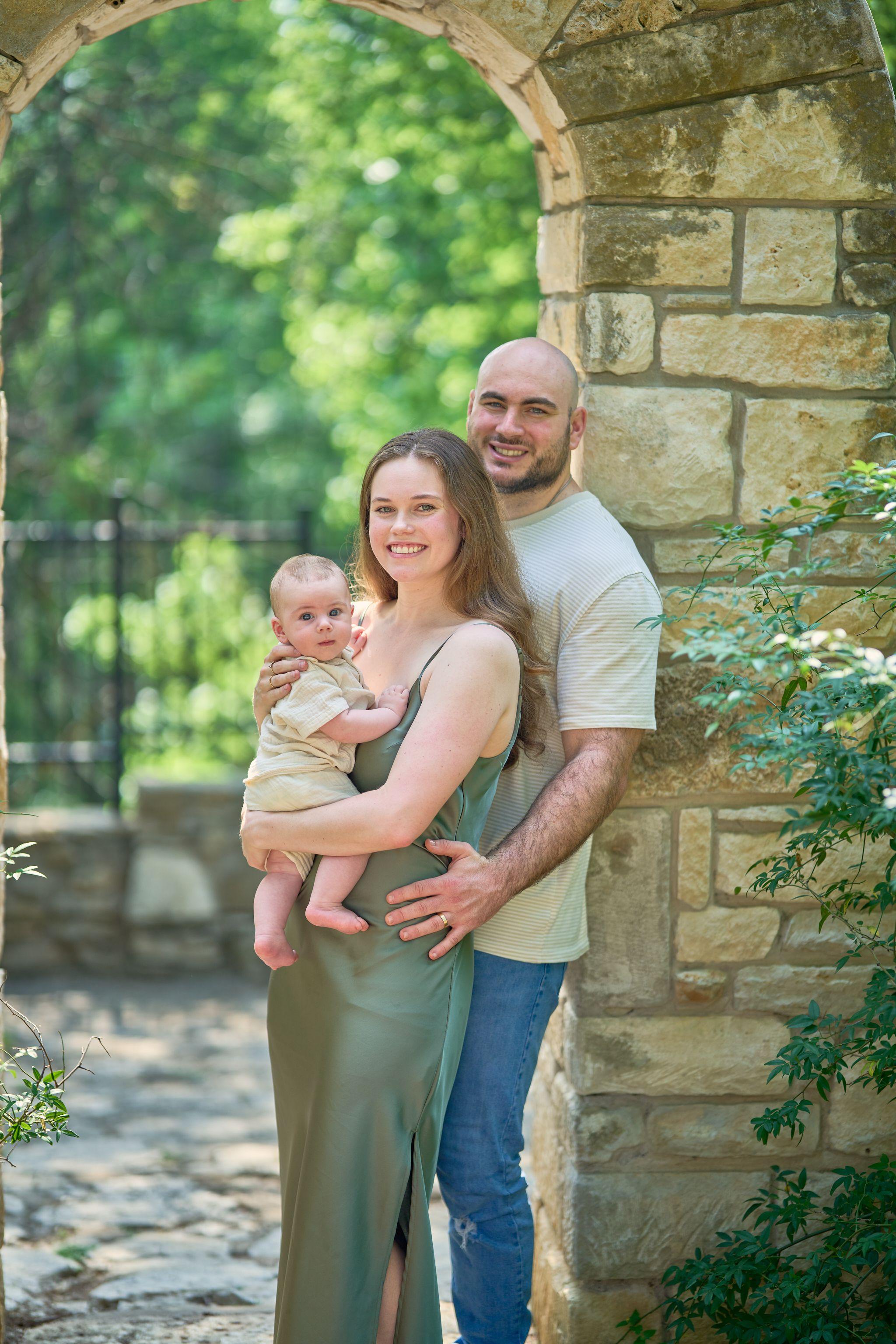 Family holding their baby beside the cut stone wall at Mayfield Park — Mayfield Park photography, Austin A family holding their baby beside the cut stone wall at Mayfield Park
