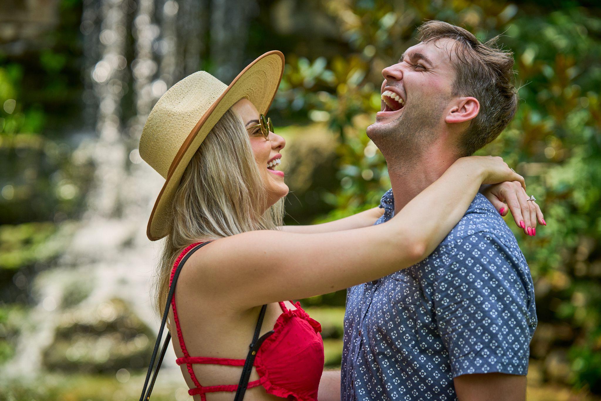 Woman in a straw hat throwing her arms around a laughing man among the garden greenery — Zilker Botanical Gardens photography, Austin A woman in a straw hat throwing her arms around a laughing man among the garden greenery
