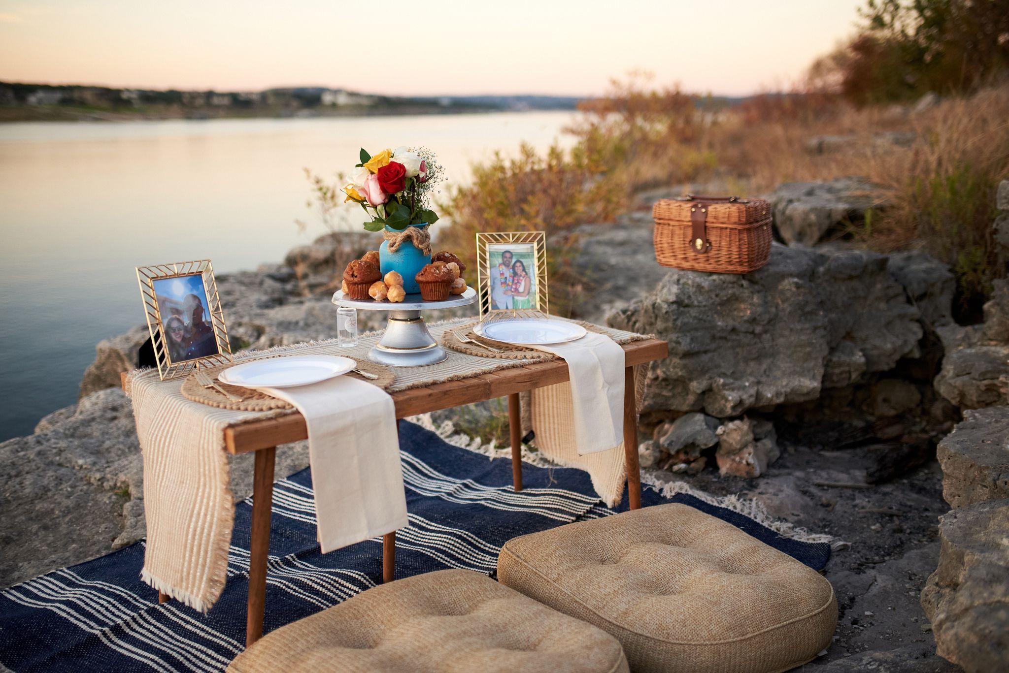 Low picnic table set with flowers, pastries and a framed photo on a limestone bluff — Engagement & Proposals photography, Austin A low picnic table set with flowers, pastries and a framed photo on a limestone bluff above the lake.