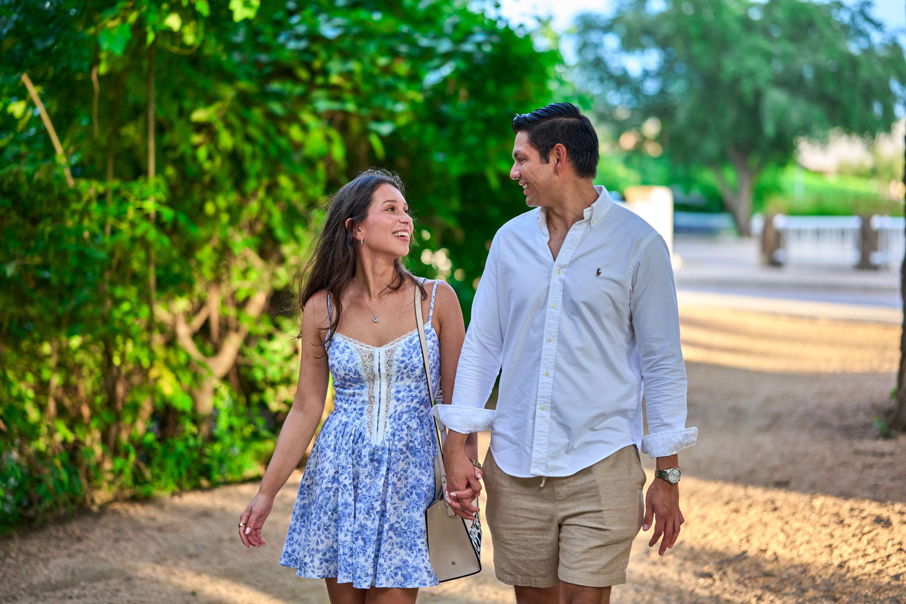 Couple walking hand in hand along a shaded green path — Engagement & Proposals photography, Austin A couple walking hand in hand along a shaded green path.