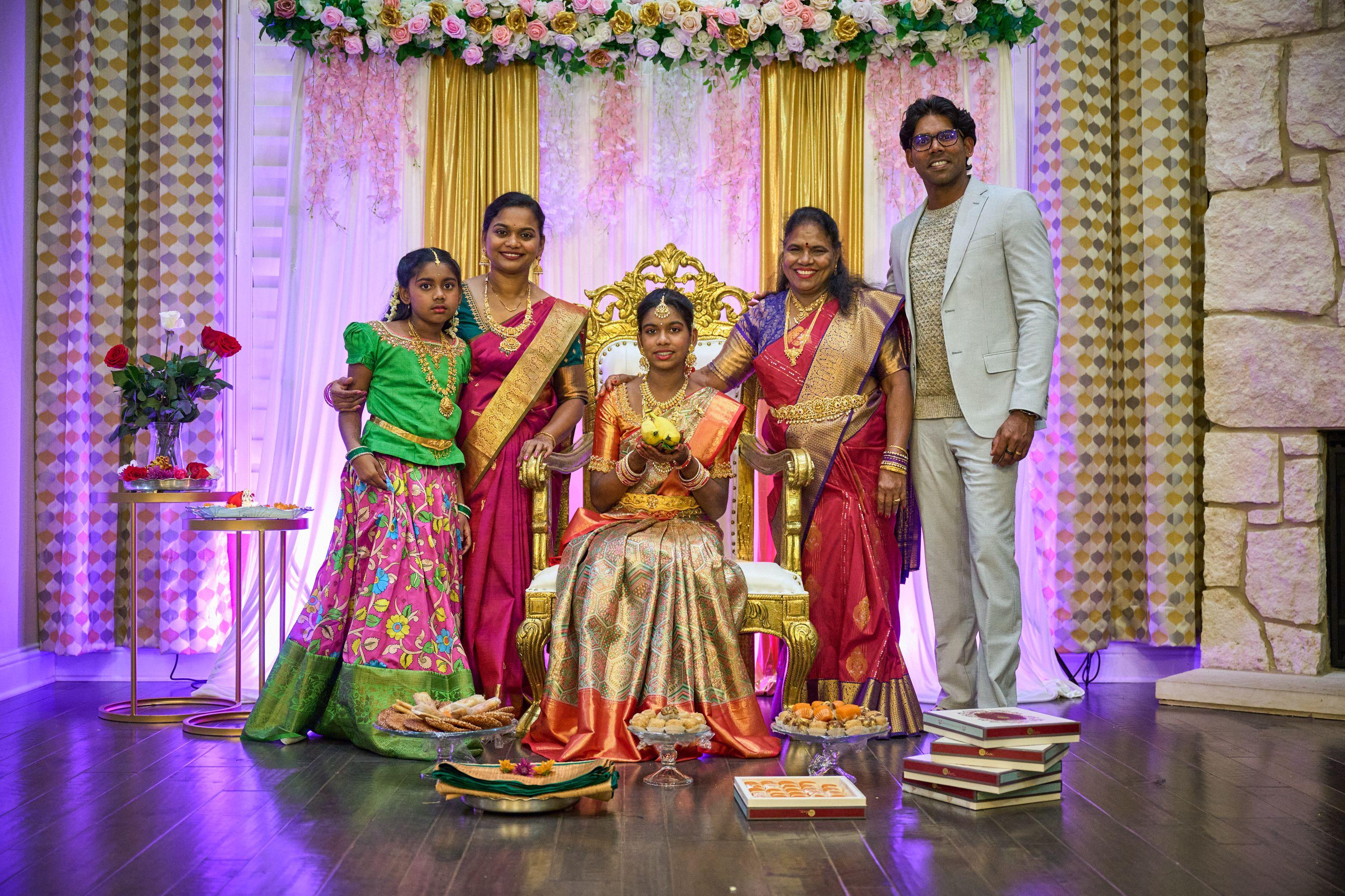 Young woman seated on a decorated throne surrounded by family in saris at a half-saree ceremony — Religious Ceremonies photography, Austin A young woman seated on a decorated throne surrounded by family in saris at a half-saree ceremony.