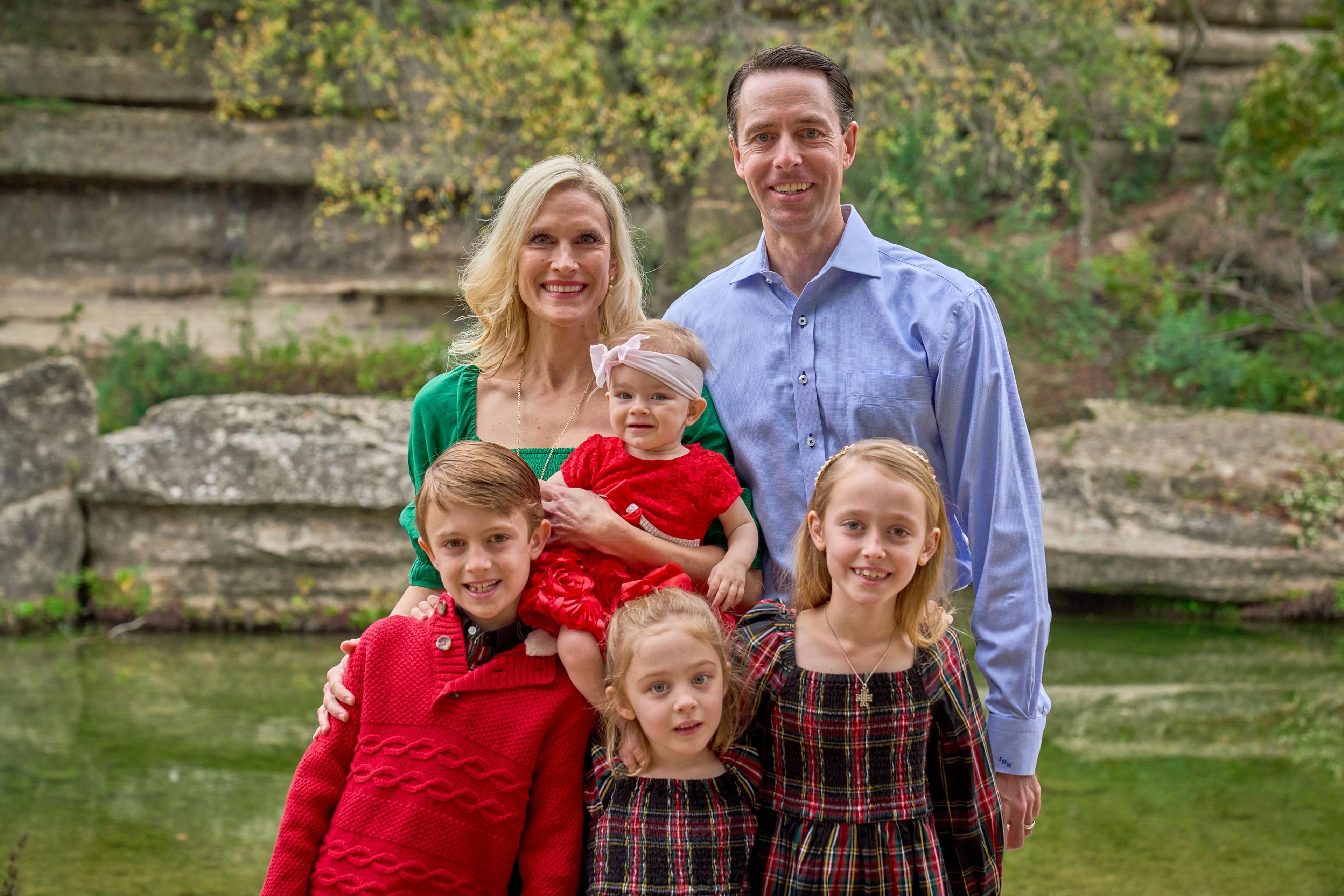 Parents and four children in red and green Christmas clothes standing close together — Bull Creek District Park photography, Austin Parents and four children in red and green Christmas clothes standing close together beside Bull Creek