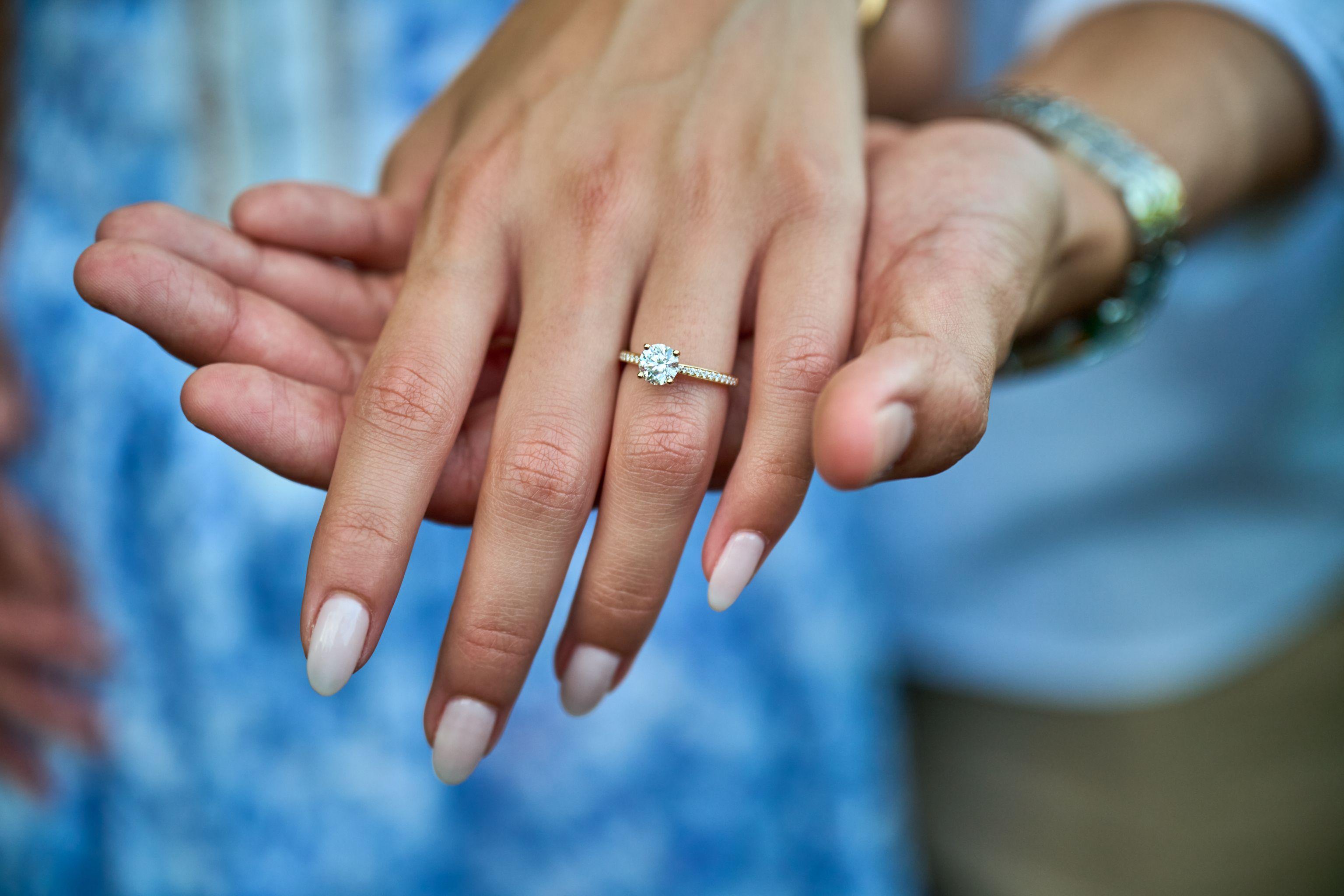 Close macro of a solitaire diamond engagement ring on an outstretched hand — Engagement & Proposals photography, Austin A close macro of a solitaire diamond engagement ring on an outstretched hand.