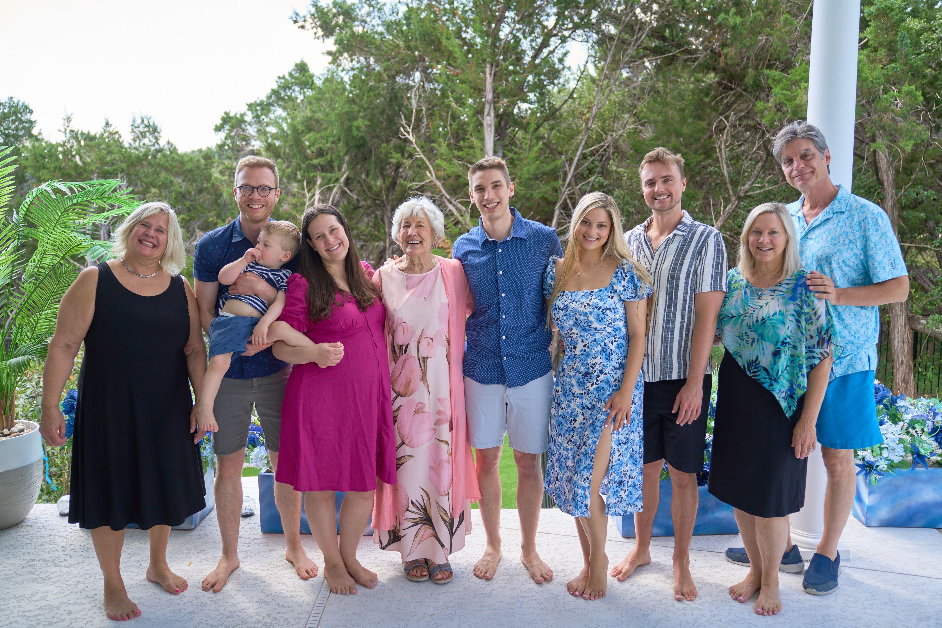 Extended family standing barefoot together on a lawn in pinks and blues — Family Portraits photography, Austin An extended family standing barefoot together on a lawn in pinks and blues.