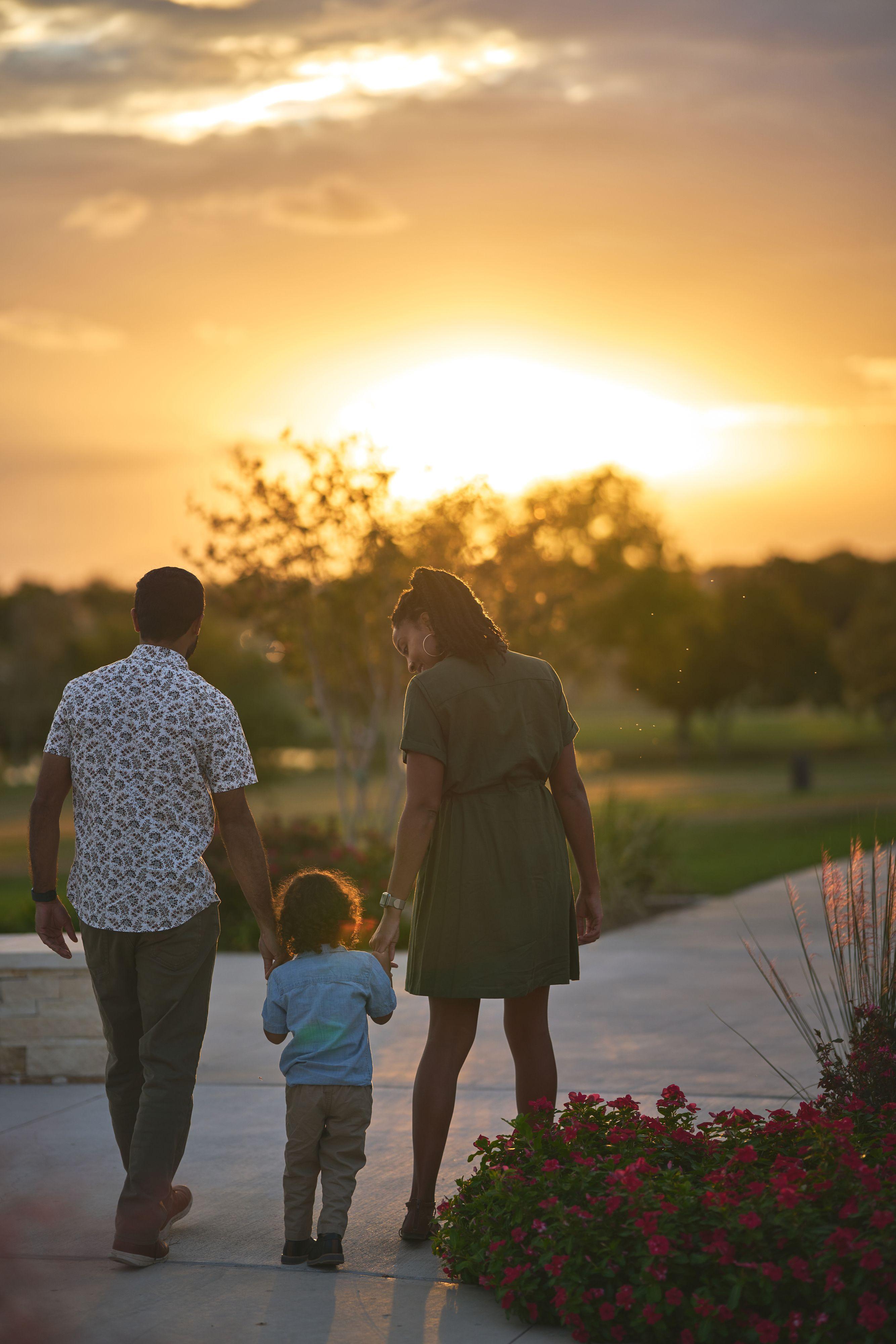 Family of three walking away hand in hand down a path at Old Settlers Park into the setting sun — Round Rock Old Settlers Park photography, Austin A family of three walking away hand in hand down a path at Old Settlers Park into the setting sun