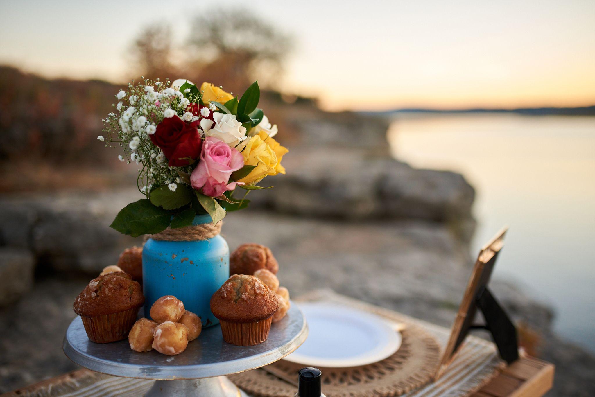 Close view of a proposal picnic — a blue vase of roses beside a cake stand of pastries — Engagement & Proposals photography, Austin A close view of a proposal picnic — a blue vase of roses beside a cake stand of pastries.