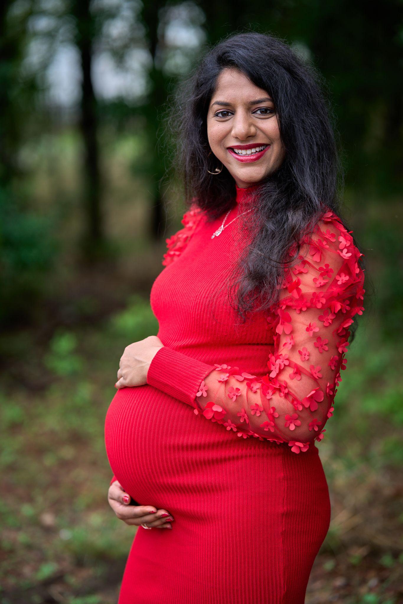Expectant mother in a red dress among trees at golden hour — Georgetown Blue Hole Park photography, Austin Expectant mother in a red dress among trees at golden hour