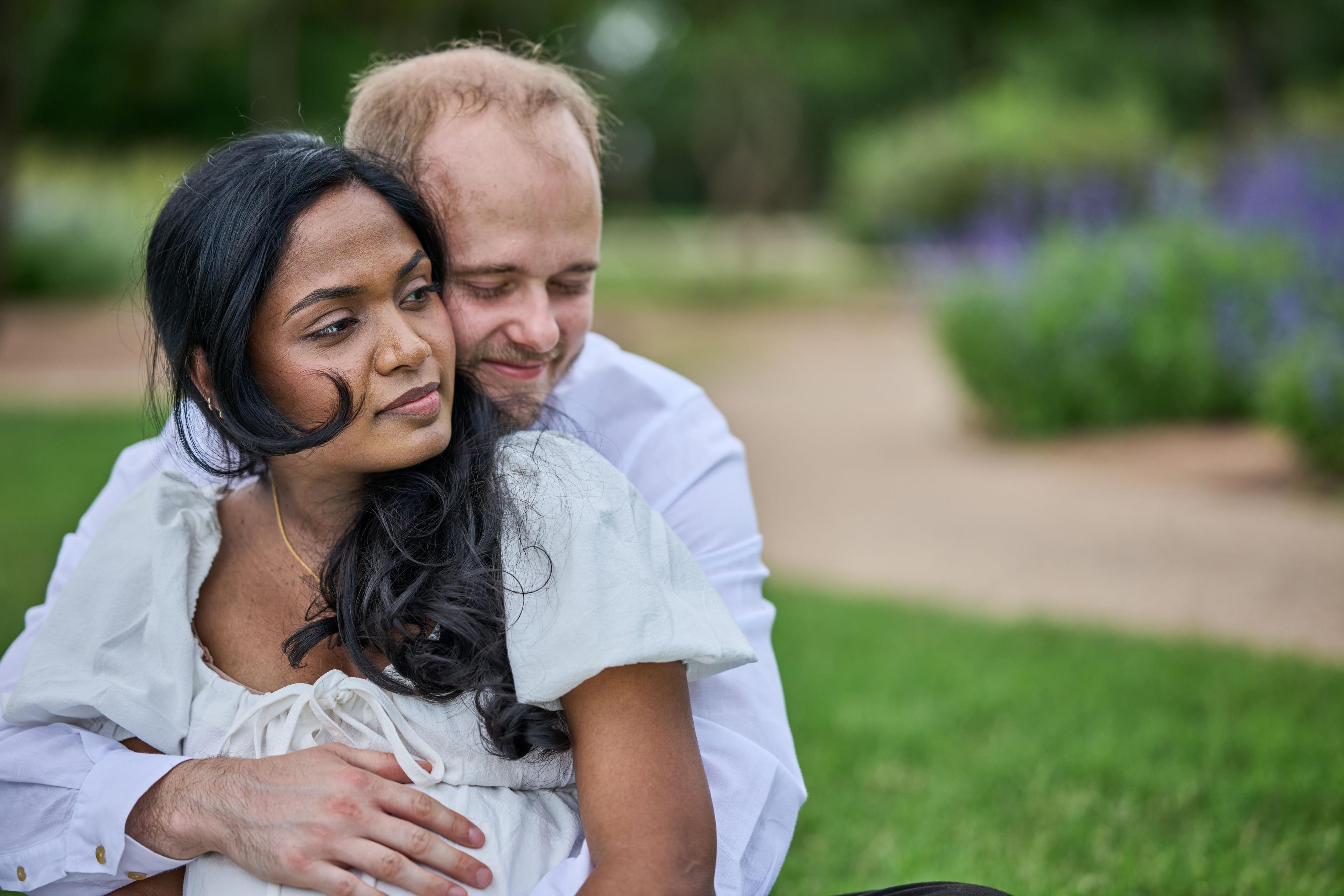 Expectant couple sitting together on a blanket on the lawn at Mueller Lake Park, laughing — Mueller Lake Park & Butterfly Garden photography, Austin An expectant couple sitting together on a blanket on the lawn at Mueller Lake Park, laughing