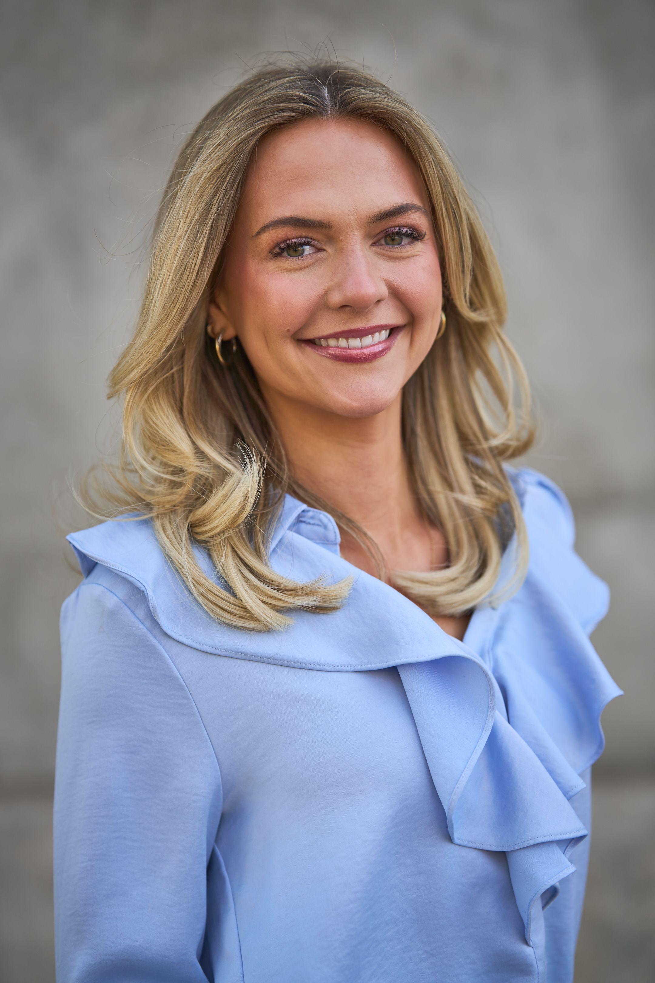 Woman in a pale blue ruffled blouse in a three-quarter pose against a neutral background — Business headshots, Austin A woman in a pale blue ruffled blouse in a three-quarter pose against a neutral background